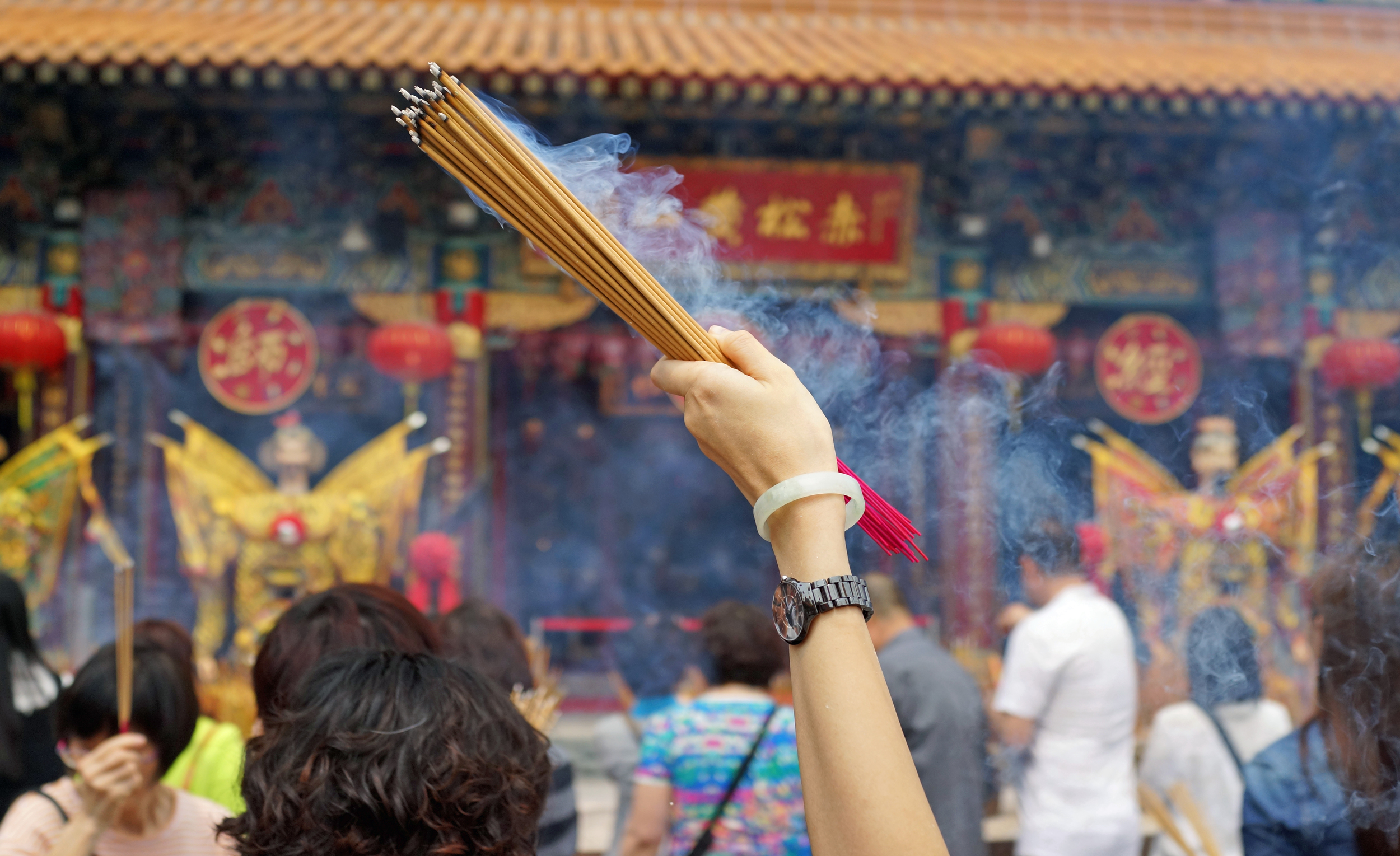 A devotee waving incense at the amazing Sik Sik Yuen Wong Tai Sin Temple