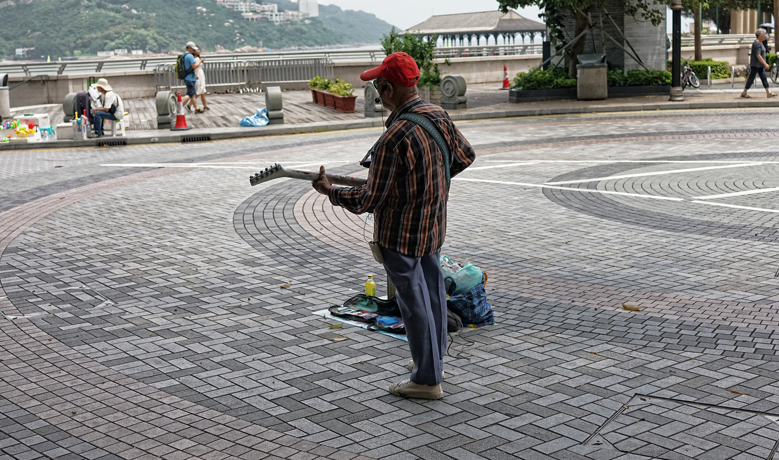 I could be kind and say that this crusty old codger is a legend in Hong Kong but he is not, I would cheerfully pay him to leave the area, he is that bad . He reminds me of Charlie Watts of the Rolling Stones who I am sure died and was stuffed about 20 years ago. This chap has played at Stanley at the weekend for a long time and can be seen during the week on the bridge leading to the Star Ferry in Central alternating between cover versions of Elvis and the Shadows, in English.