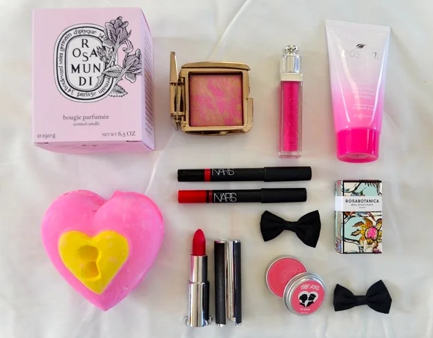 L-R: Diptyque Rosamundi Candle, Hourglass Ambient Lighting Blush in Radiant Magenta, Dior Addict Lip Gloss in Exquise, Boscia Tsubaki Deep Hydration Sleeping Mask, Nars Velvet Gloss Pencil in Mexican Rose, Nars Satin Lip Pencil in Luxembourg, Lush Love Locket Bath Bomb*, Givenchy Le Rouge Lipstick in Fuschia Irresistible, Lush The Kiss Lip Gloss*, Balenciaga Rosabotanica