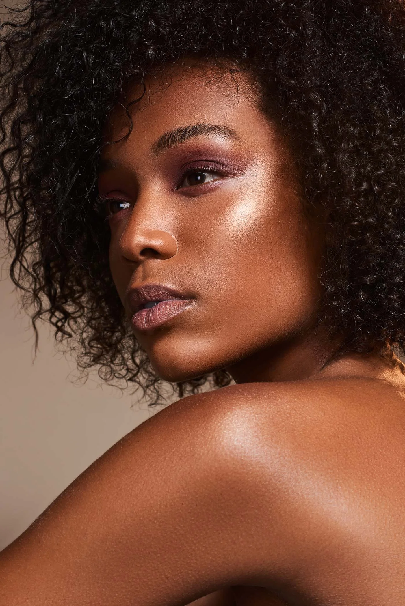 Black beauty model with shimmery makeup and afro hair during studio shoot