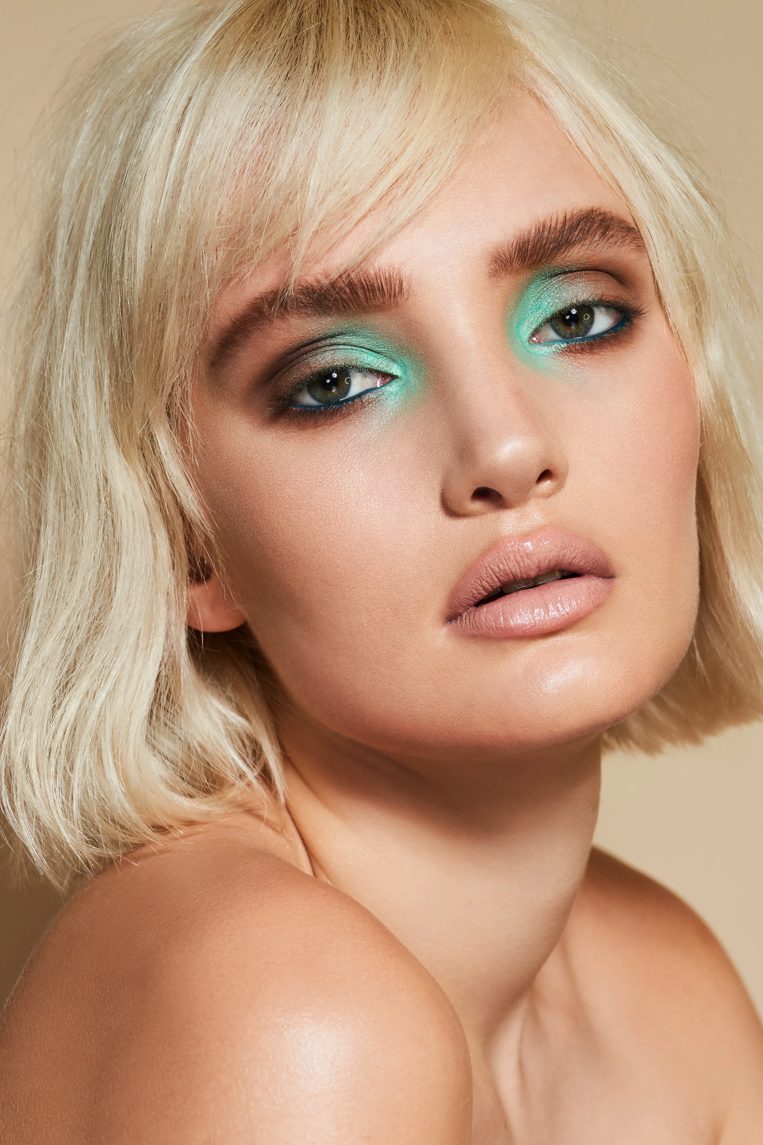 pale beauty model with blonde hair and turquoise coloured eyeshadow makeup 