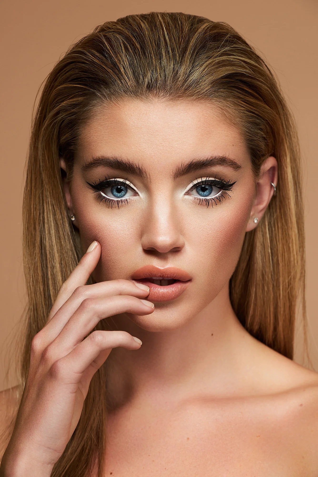 Female beauty model with dark blonde hair, black eyeliner and 60's style makeup 