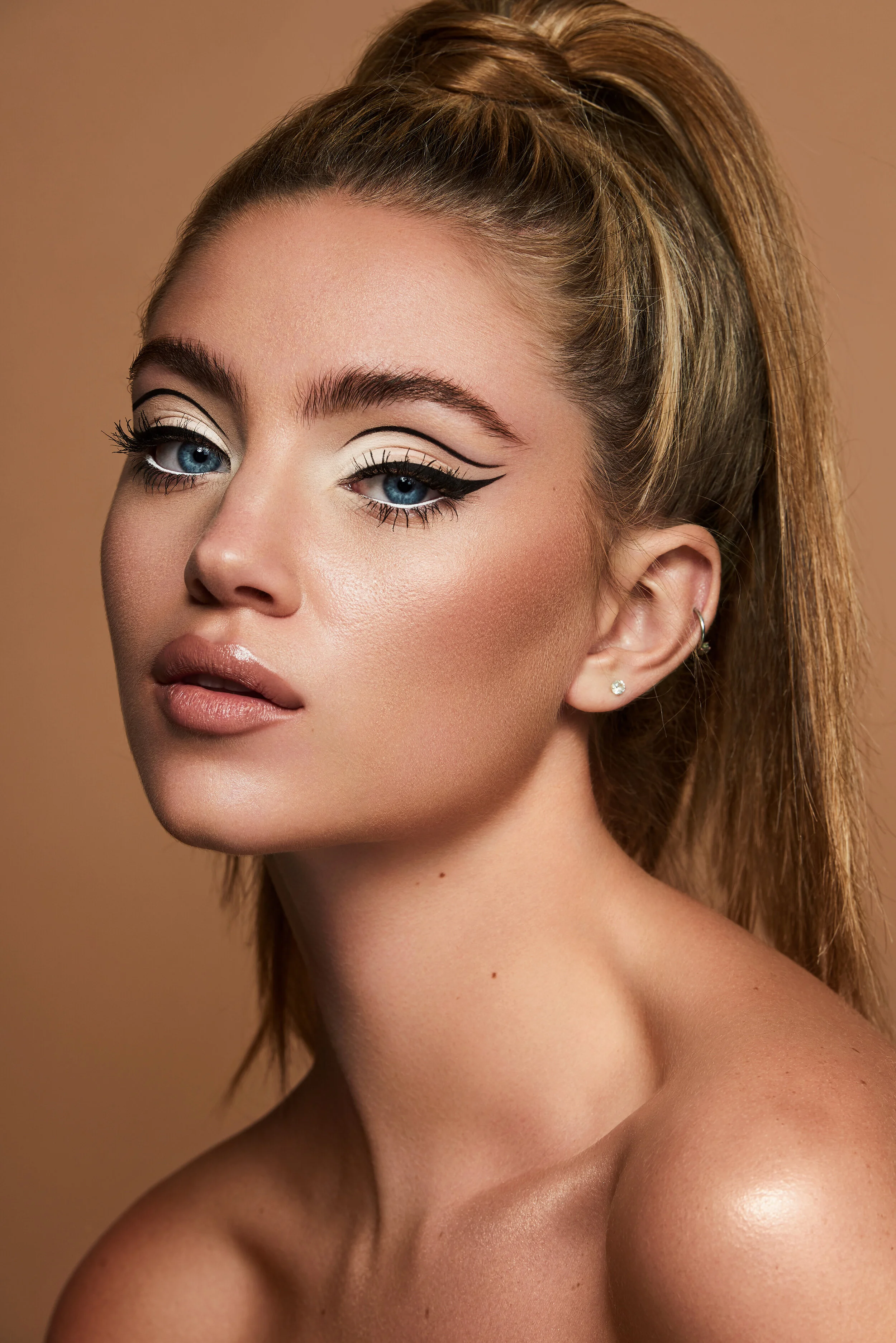 Female beauty model with dark blonde hair in a pony tail and 60's style makeup 