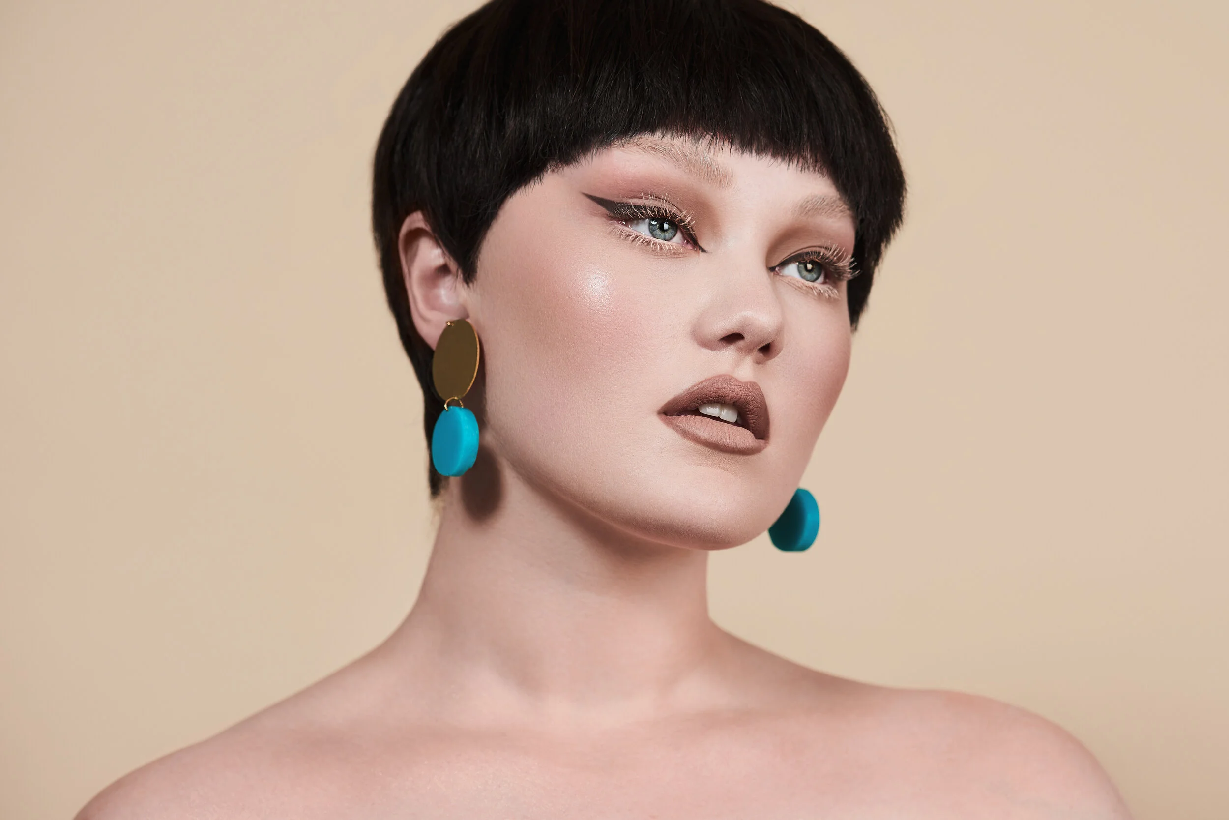 Porcelain looking beauty model in front of cream backdrop with white eyelashes wearing Bybri Jewellery
