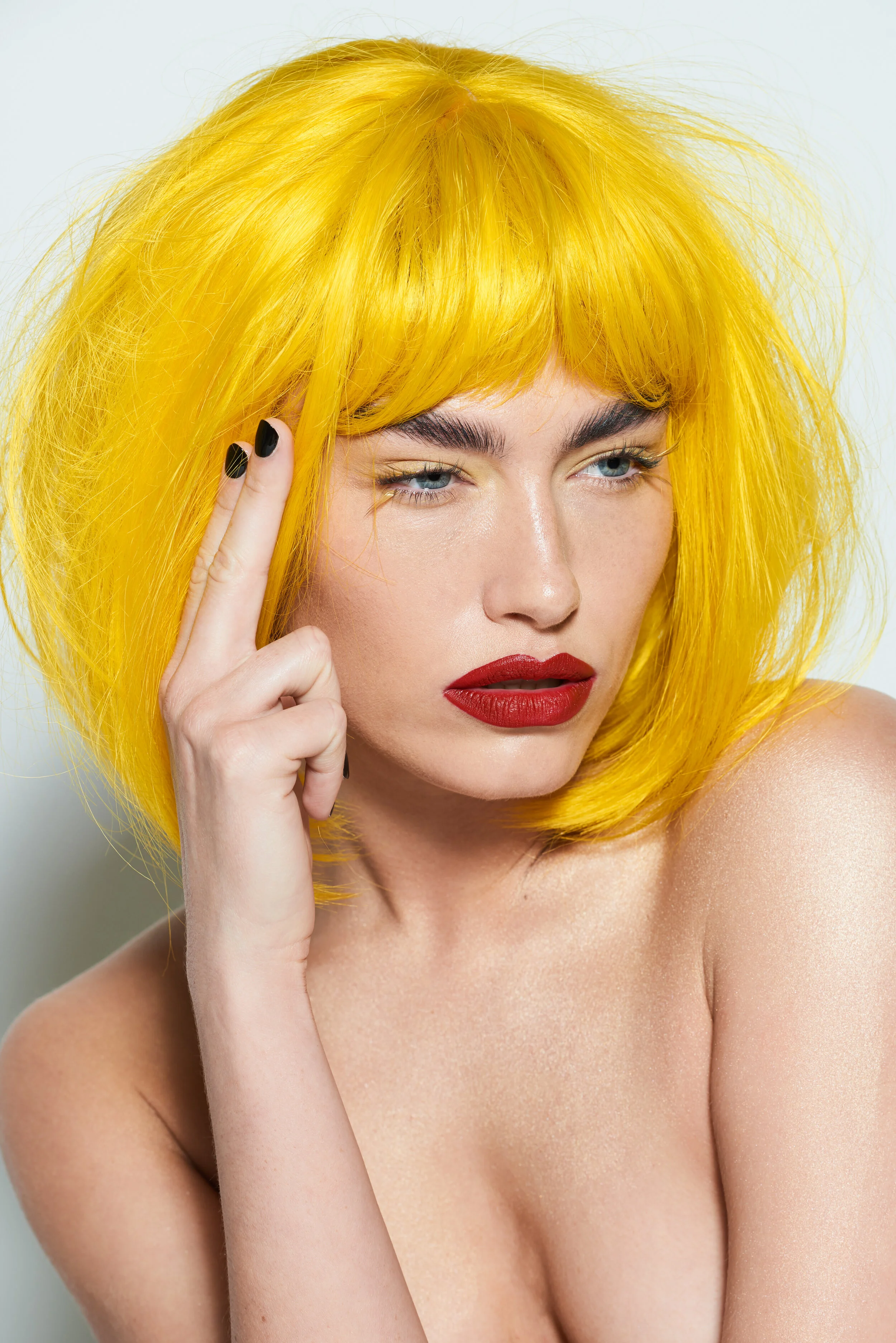 Female model wearing a yellow wig with red lipstick for LGBT beauty studio shoot 