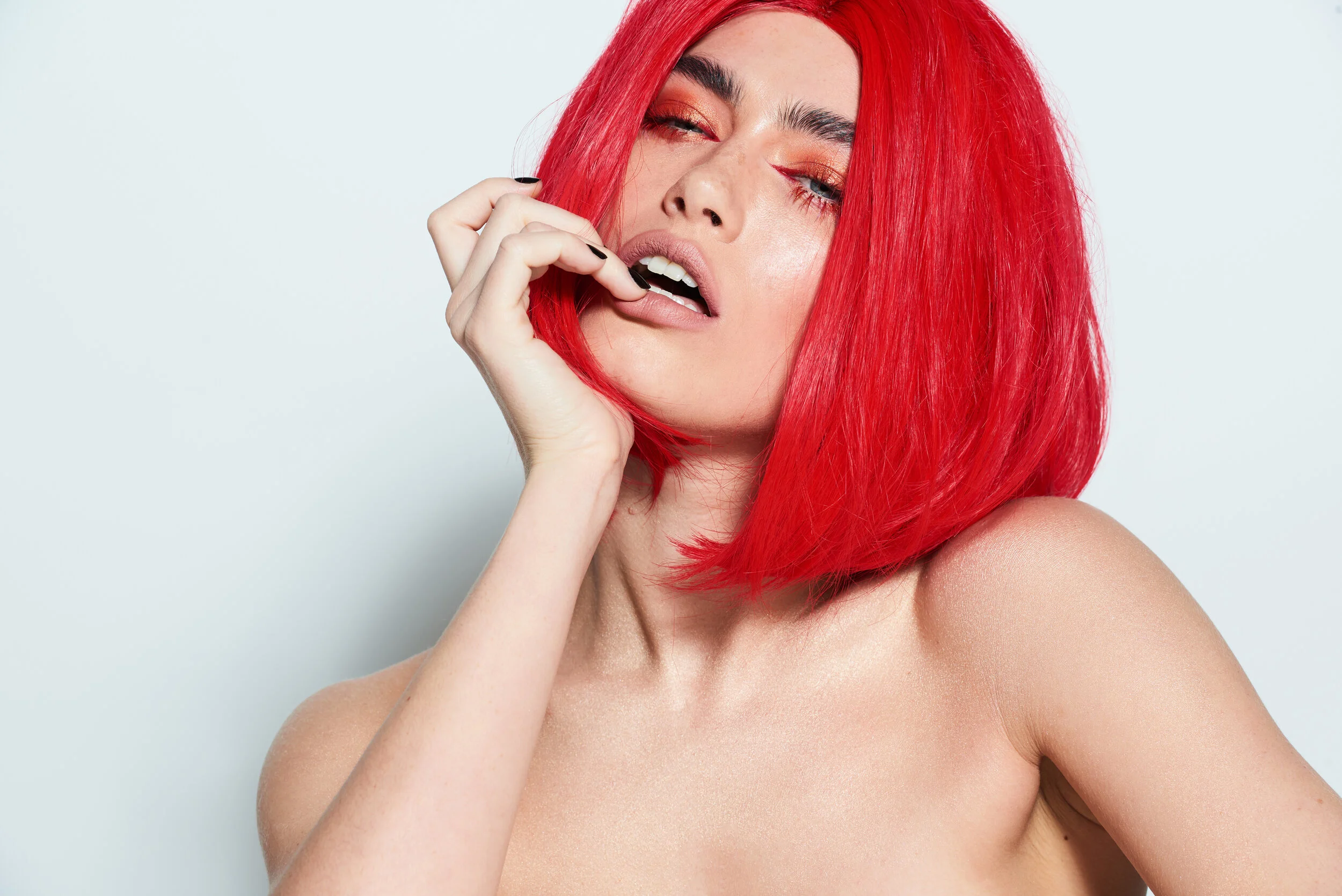 Female model wearing a red wig for LGBT beauty studio shoot 