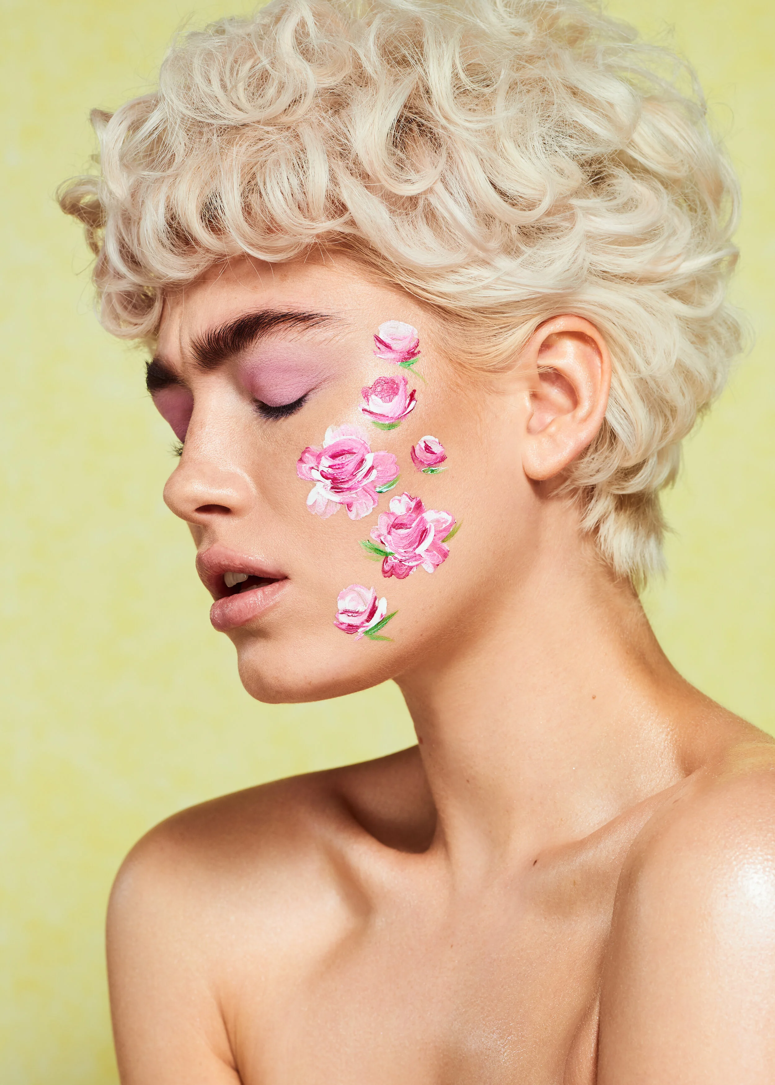 female model with short curly blonde hair and flower face paint art