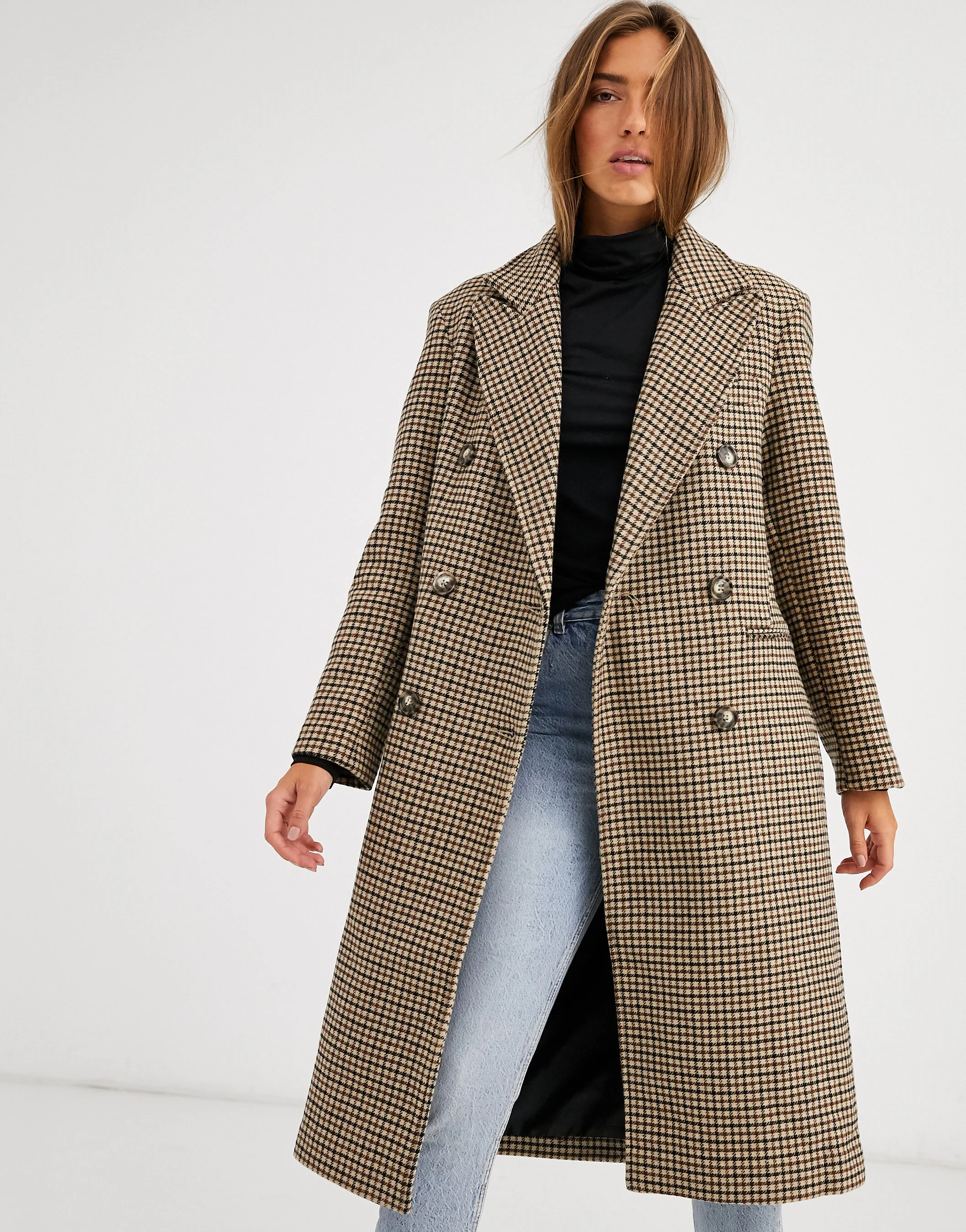 Female model in a white studio wearing a long coat for ASOS