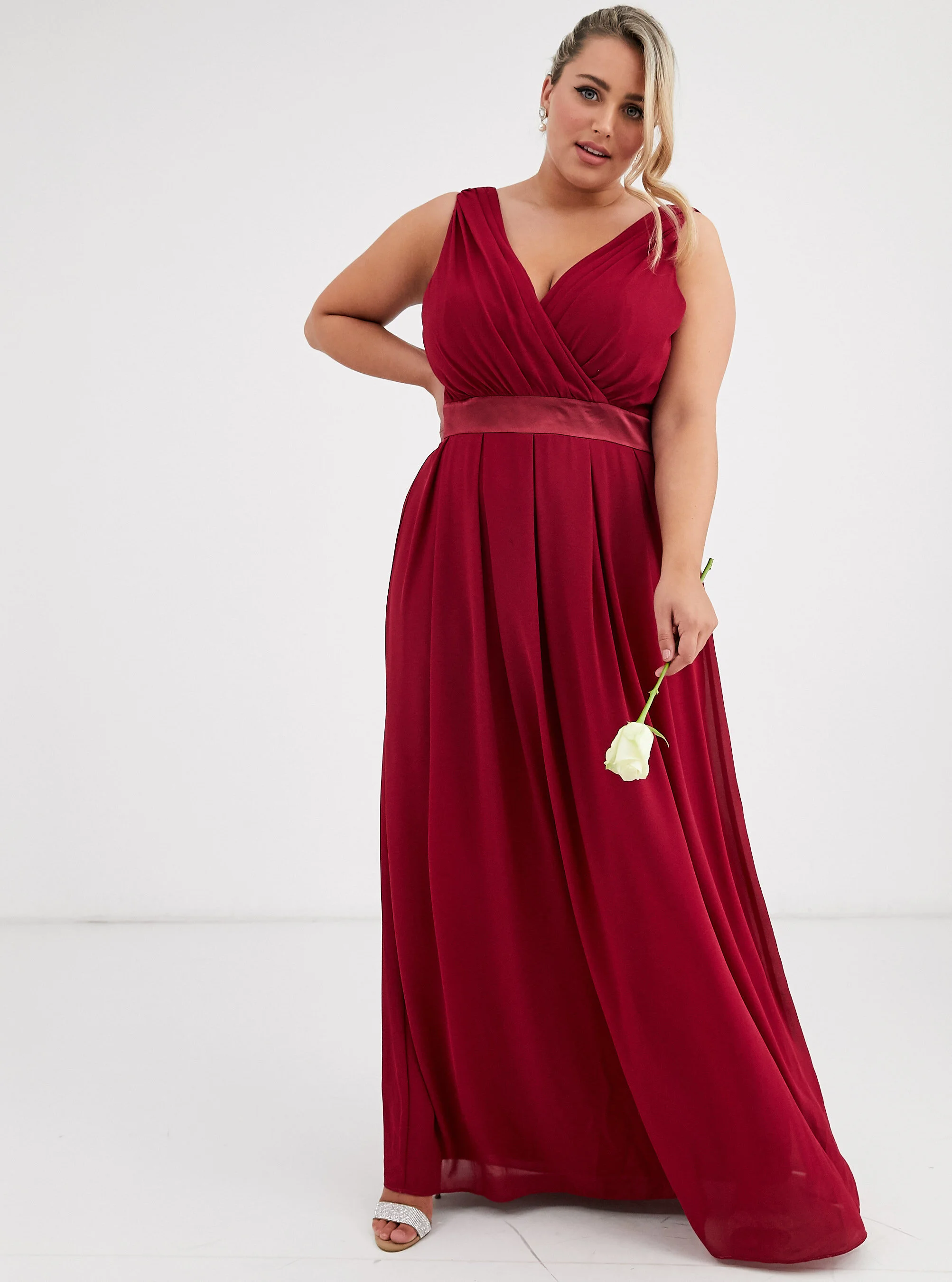 Plus size model wearing a red bridesmaid dress in a white studio for ASOS