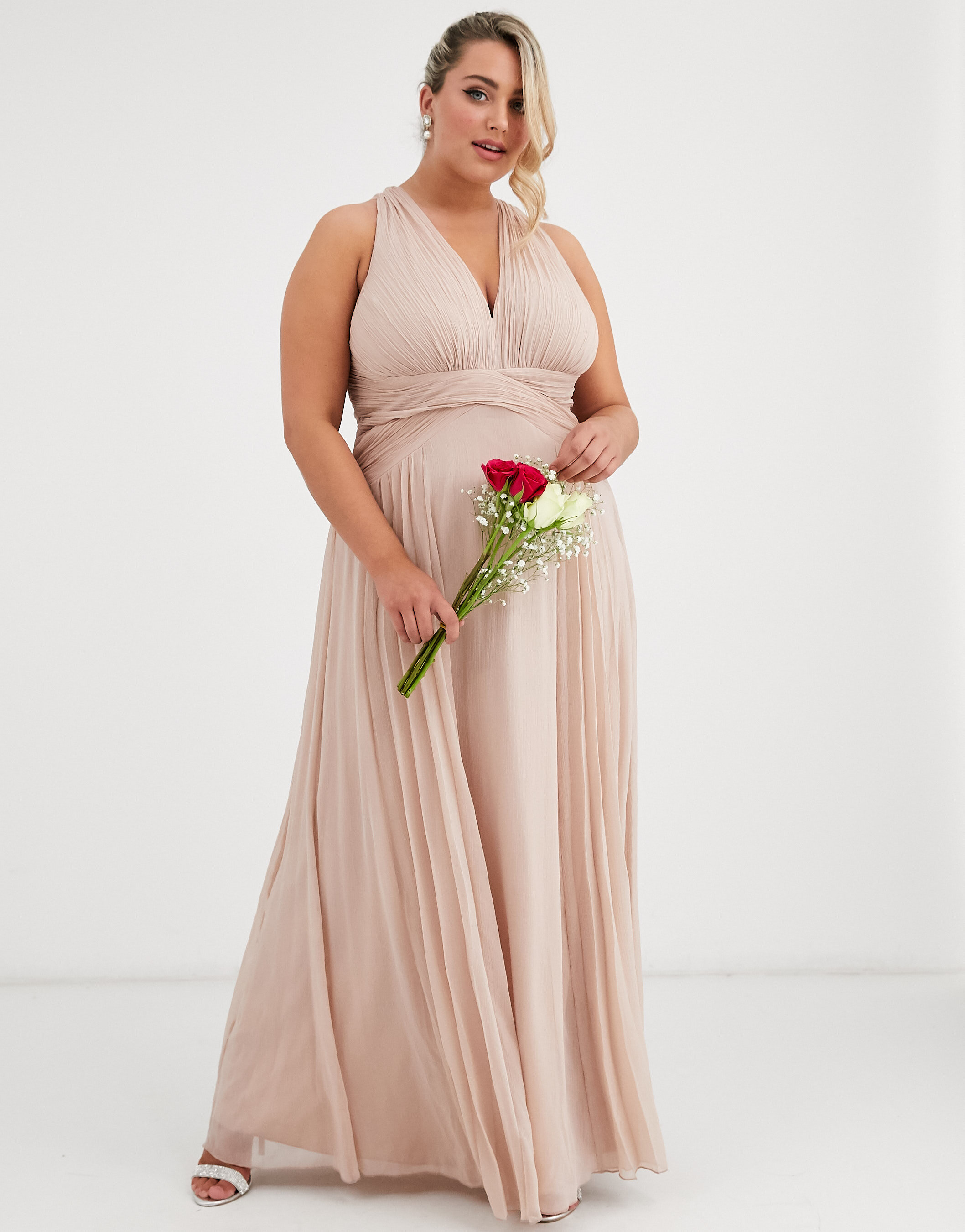 Plus size model wearing a cream bridesmaid dress in a white studio for ASOS