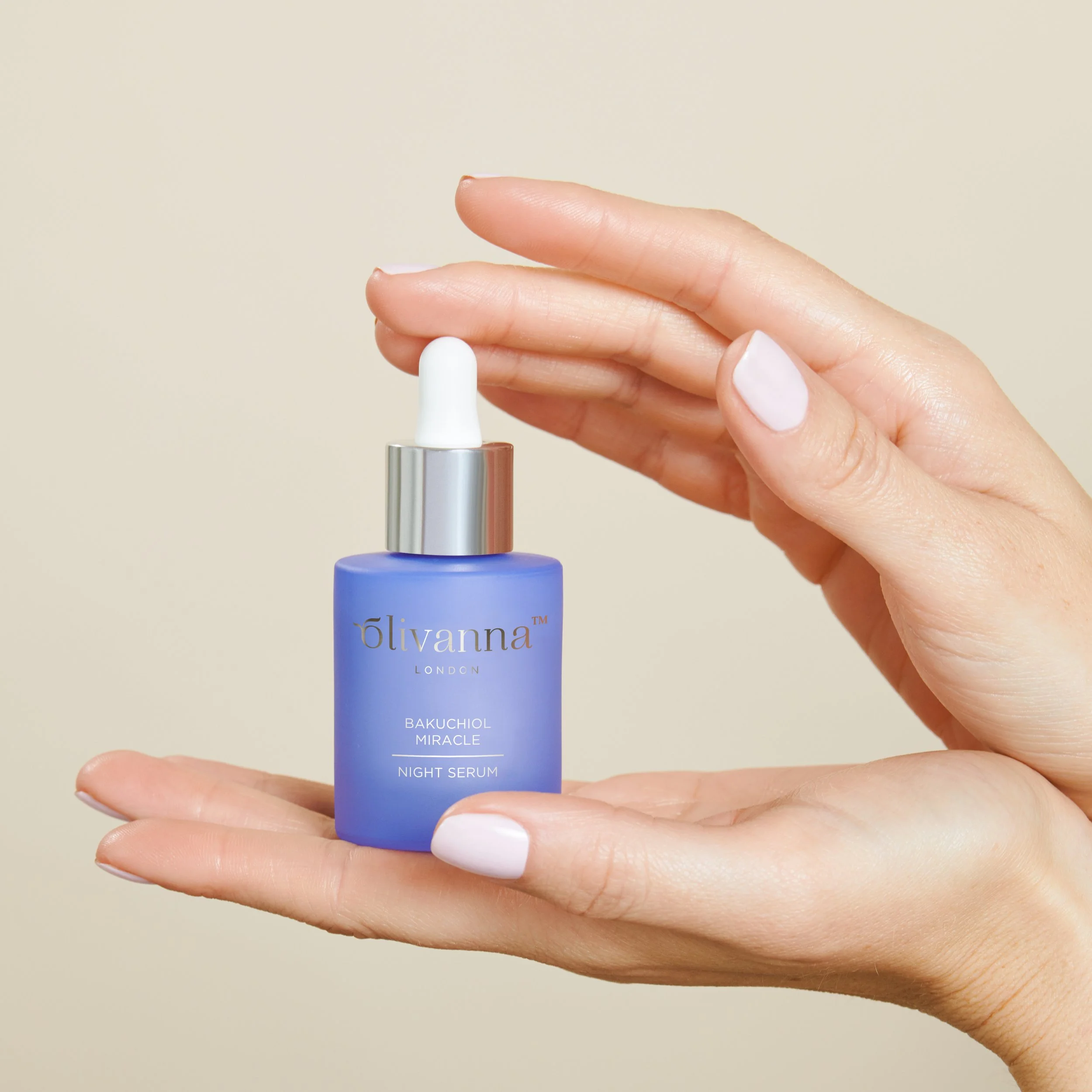 Womens hands holding a bottle of Olivanna oil for beauty product photoshoot