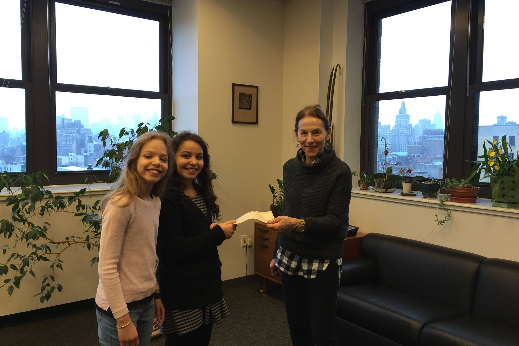 Jasmine and Angelina deliver their check to Deputy Director, Stephanie Cowles