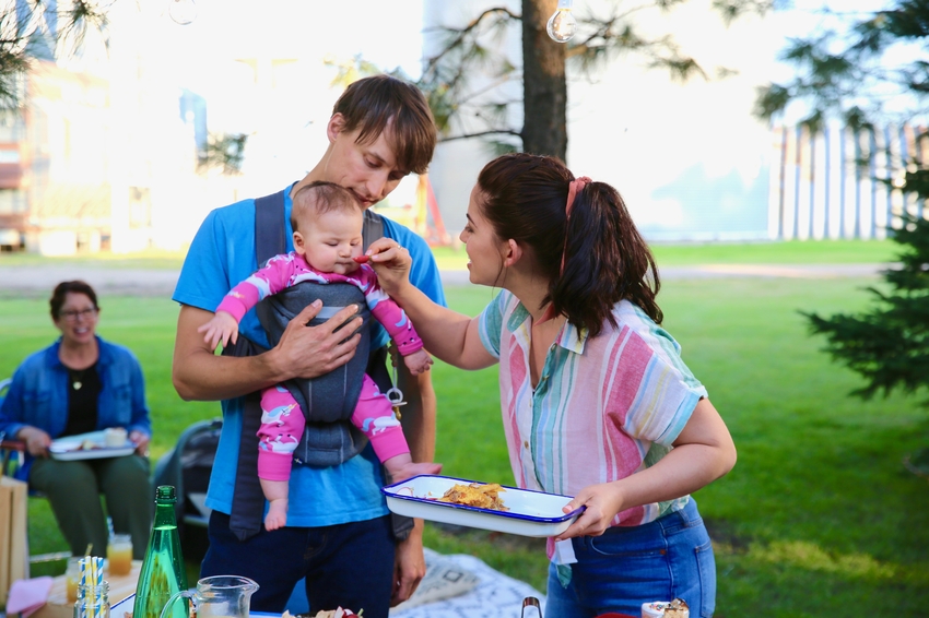 Molly helps Nick prep a plate to eat while he carries their baby .jpeg