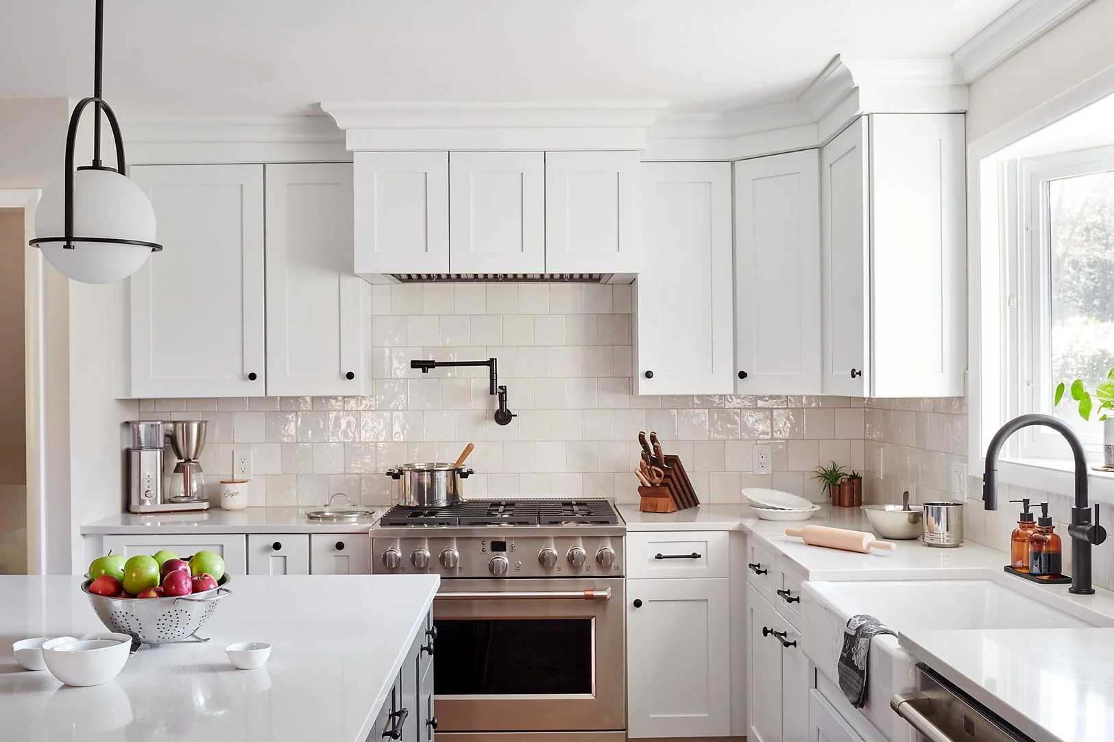 Kitchen with white cabinetry, a stainless steel range and pot filler.