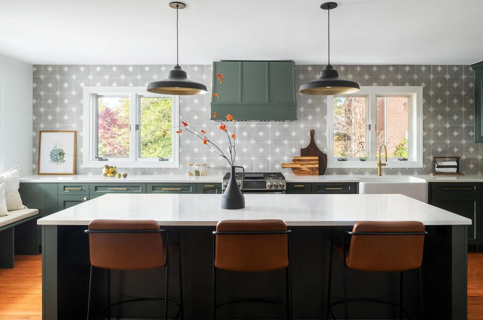 Kitchen with dark green cabinetry and light gray celestial backsplash.