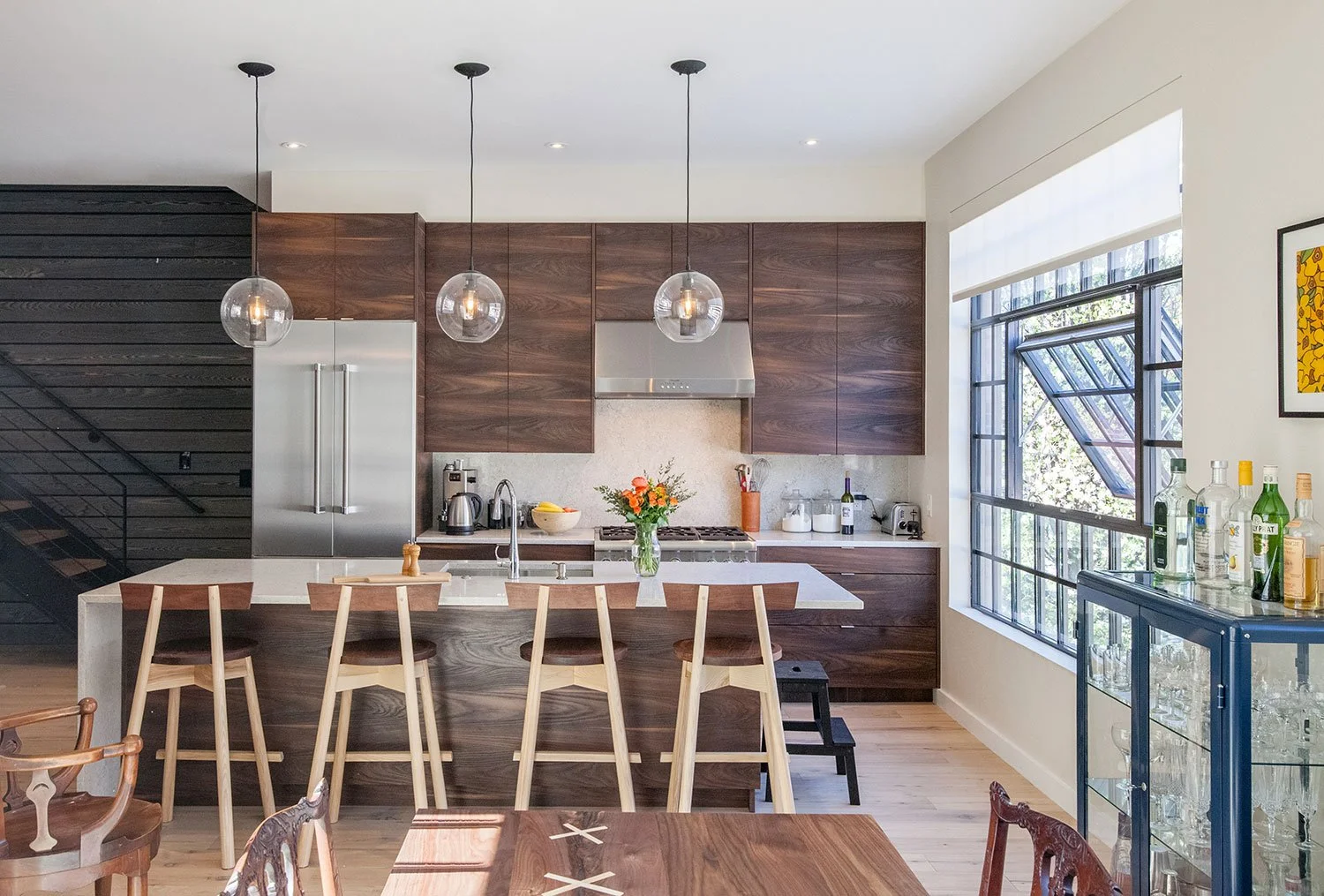 Kitchen with walnut cabinetry and a light slab backsplash.