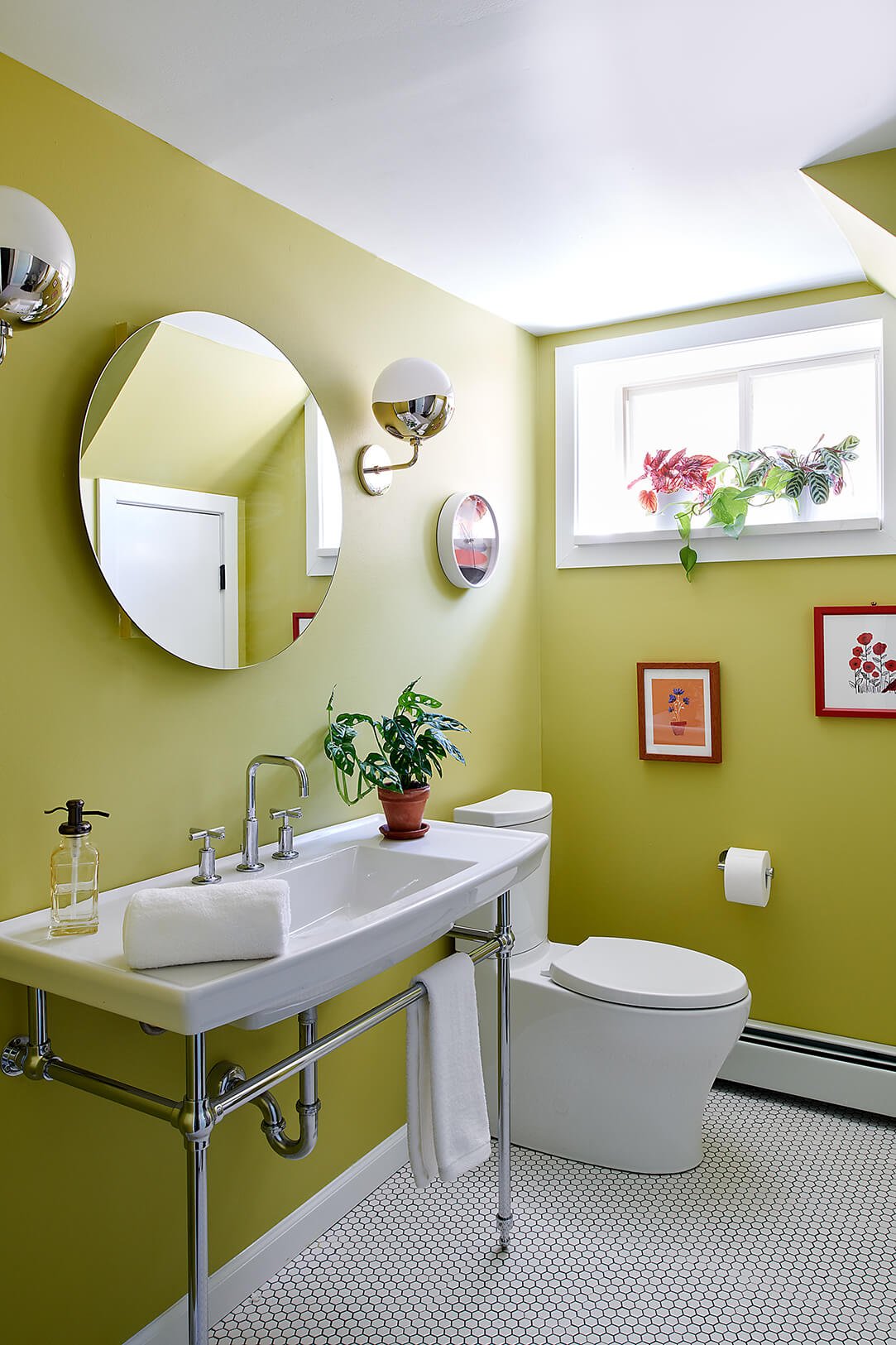 A basement apartment bathroom with a window, white fixtures and lime green walls.