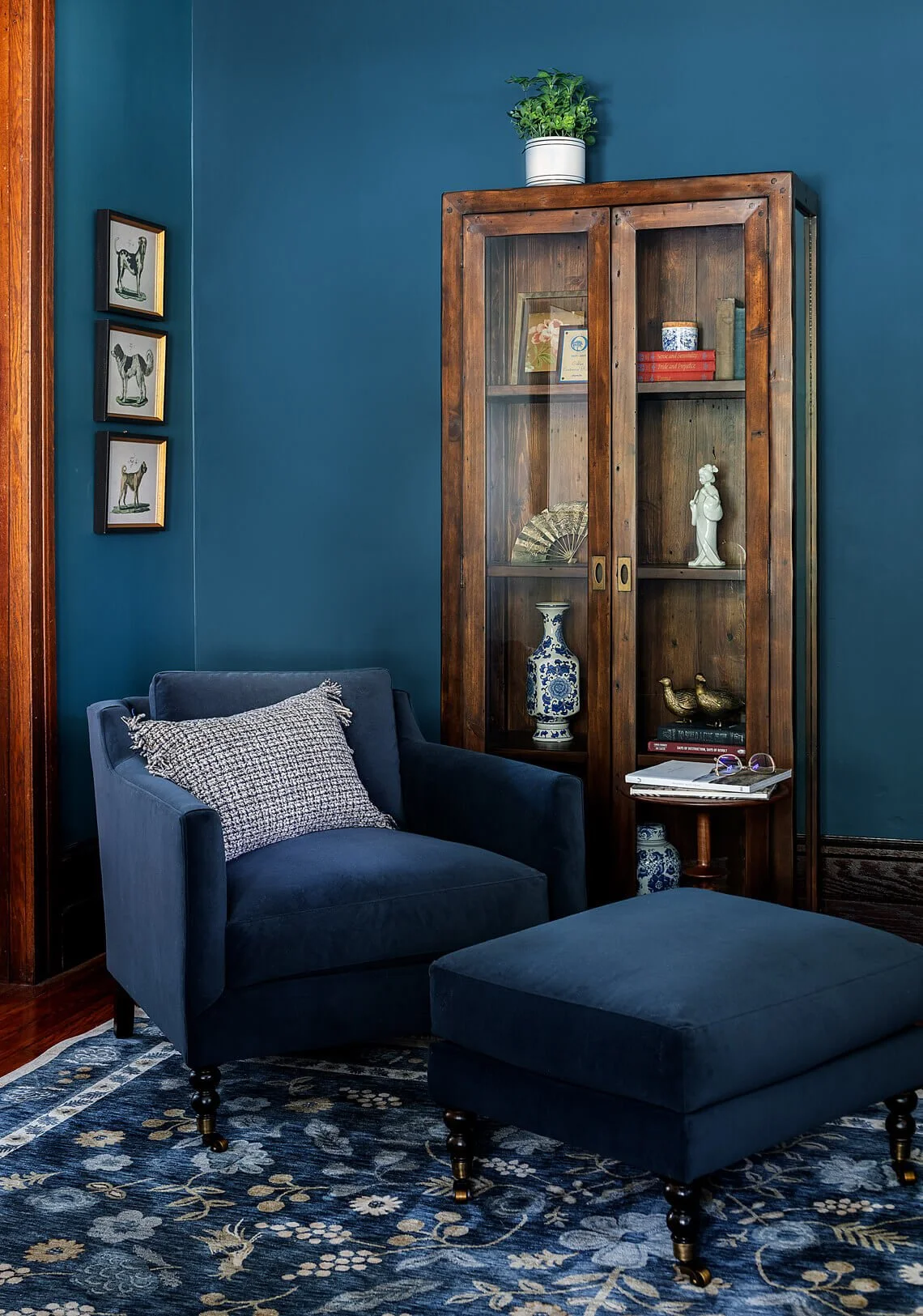 Dark blue reading chair and wood cabinet.