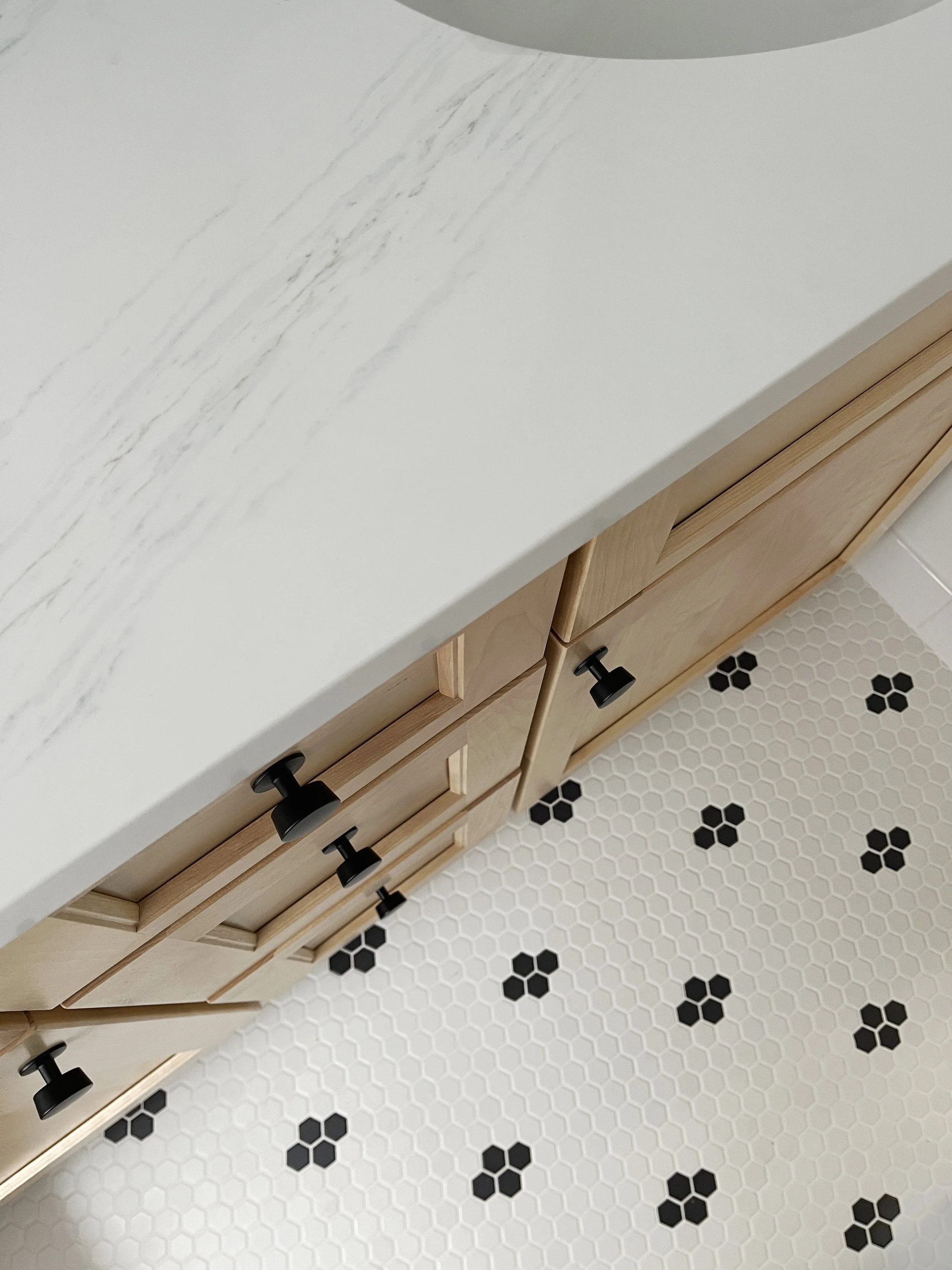 Small black and white mosaic hex floor tile in a tiny bathroom.