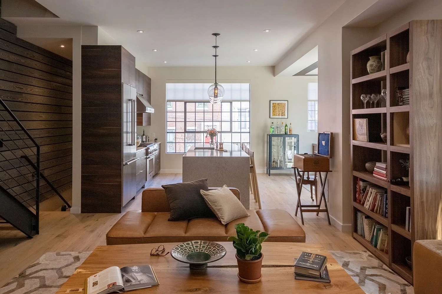 Living room open to the kitchen with a huge black steel window.