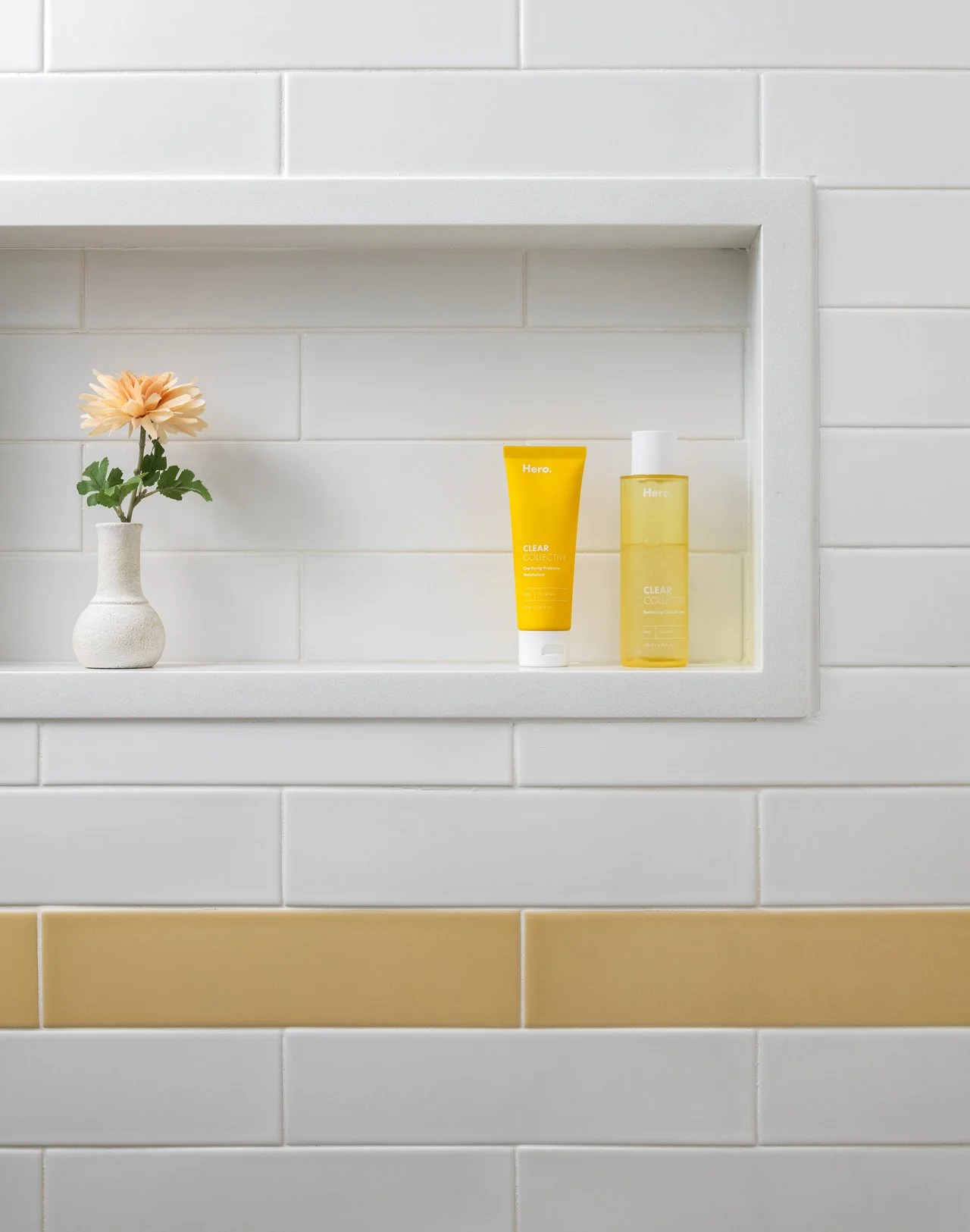 Shower niche surrounded by white and yellow subway tile.
