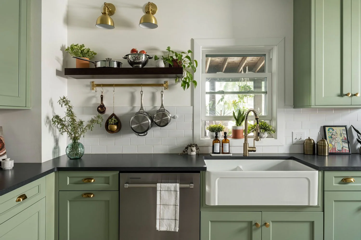Kitchen with sage green cabinetry and a white farmhouse sink.