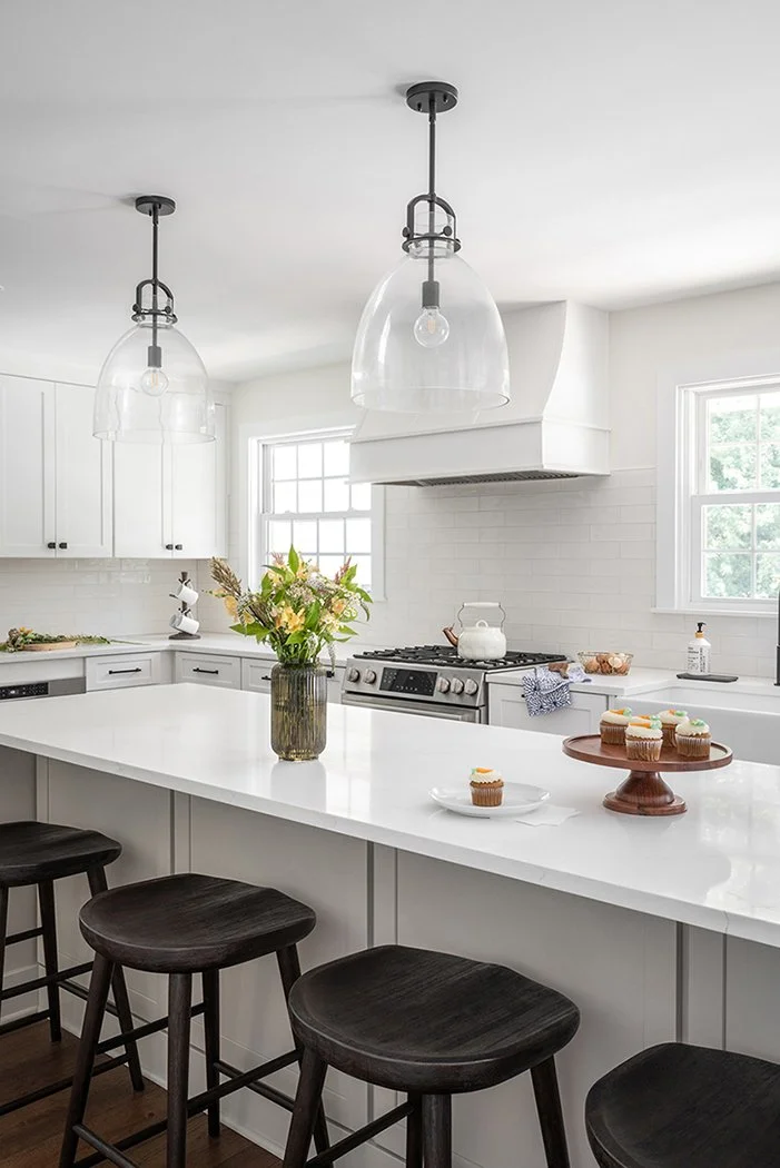 White range hood in between two windows.