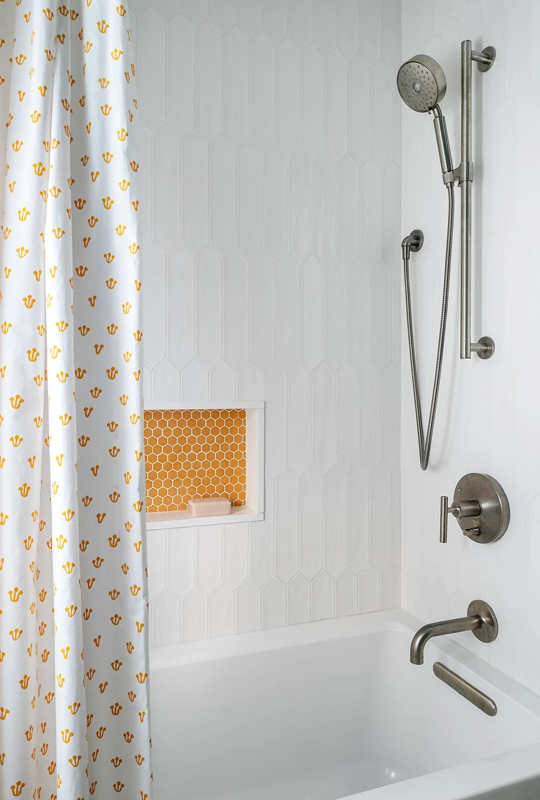 A shower with a white, gloss picket shower tile to reflect light in a small bathroom.