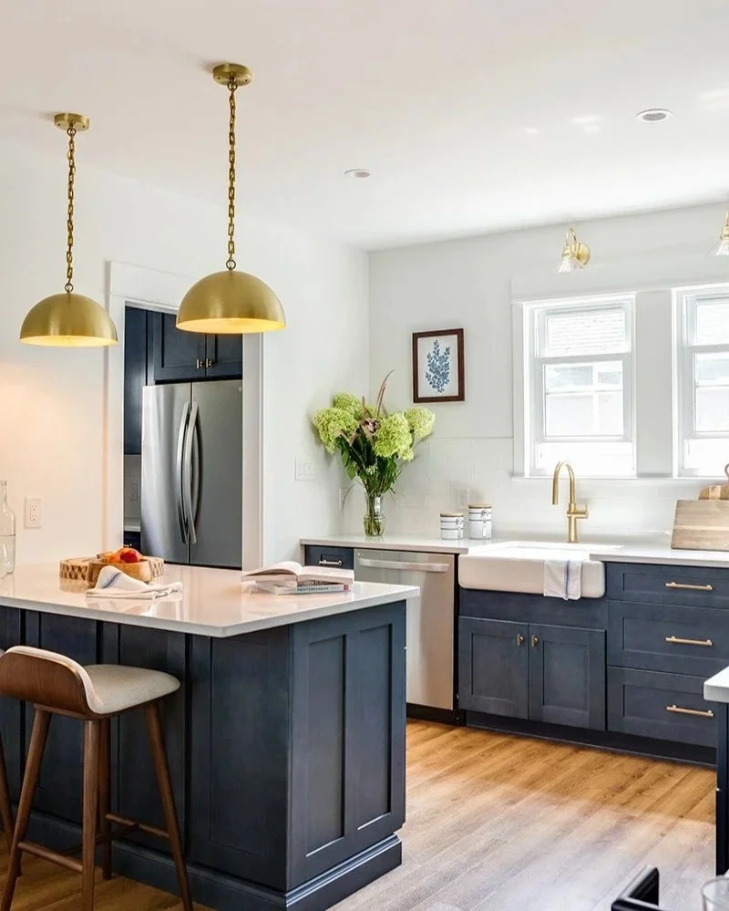 Kitchen with two windows. White walls with blue cabinetry.
