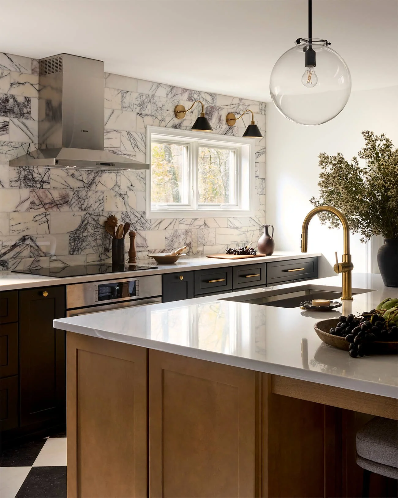 Range wall with black cabinets and violet marble backsplash.