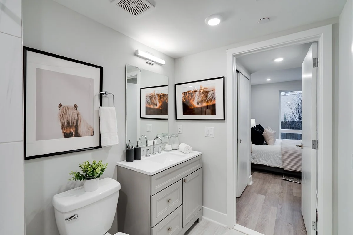 White apartment bathroom with a light gray vanity.