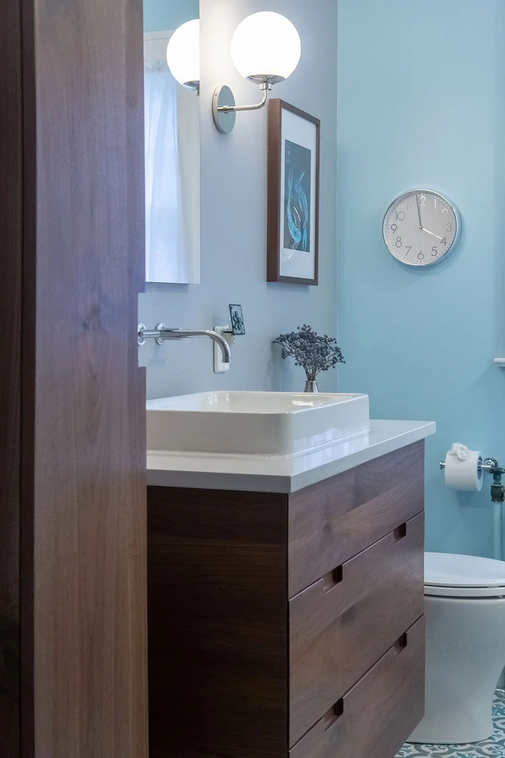 Bathroom with custom walnut vanity and cabinet.