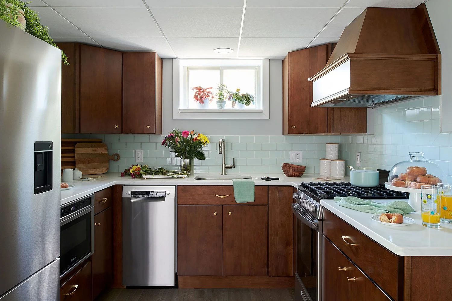Kitchen with walnut colored cabinetry and a mint green backsplash.