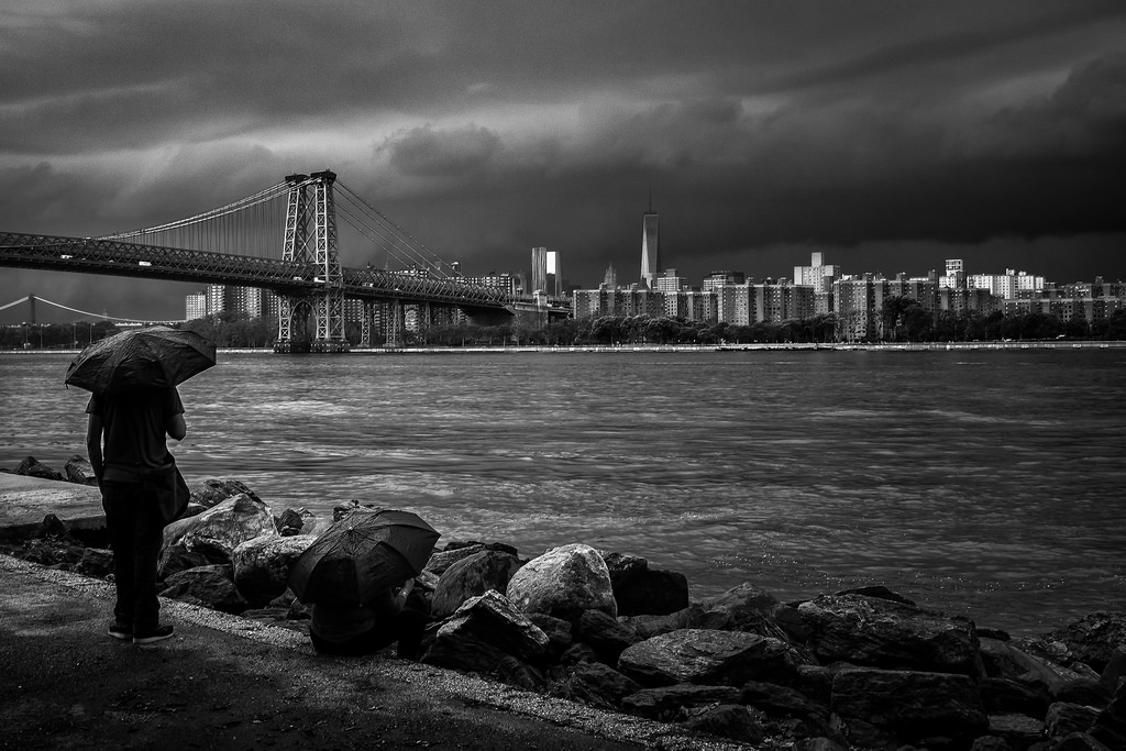 "Watching the storm roll in" June 2014, Brooklyn, New York Fujifilm X100s, 23mm, f/8, 1/150, ISO 320 This photo was taken just eight minutes earlier than the one above. I started shooting this scene down low along the rocks. But then I stood up and saw the couple with the umbrellas. As a rule of thumb, people are almost always more interesting than rocks. 