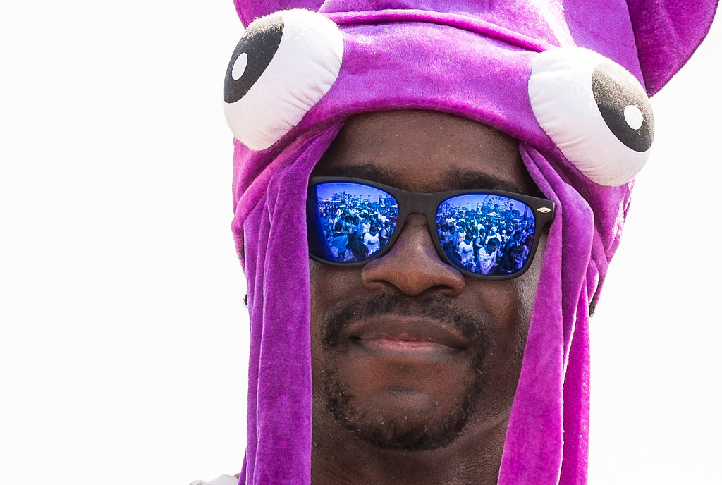 "Coney Island Reflected" June 2014, Brooklyn, New York Fujifilm XPro1, 74mm, f/5, 1/750 seconds, ISO 200 My favorite shot from Coney Island's raucous Mermaid Parade wasn't even of a mermaid. It was this quiet moment of an amused spectator, sitting on the boardwalk railing, taking in all the madness. I love how isolated he is against the blown-out sky. It's only when you see the reflections in his sunglasses that you get a sense of place. A jam-packed boardwalk with Deno's Wonder Wheel spinning in the background. 