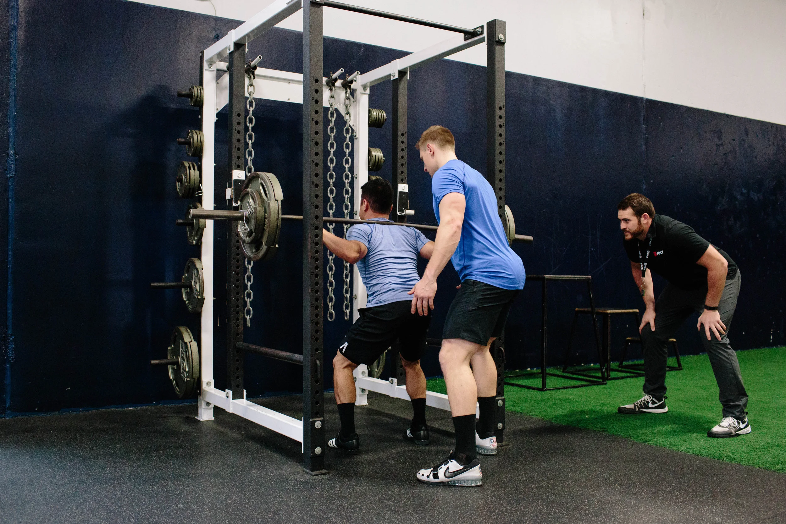 When spotting the squat, the spotter should stand directly behind the athlete and track the movement of the bar with both hands, ready to assist by touching only the weight, if necessary.