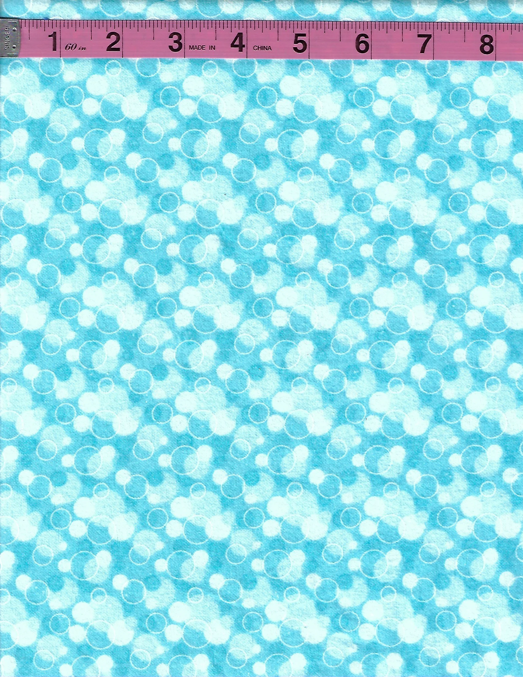 Aqua blue cotton flannel fabric with an allover pattern of white and light blue bubbles and circles