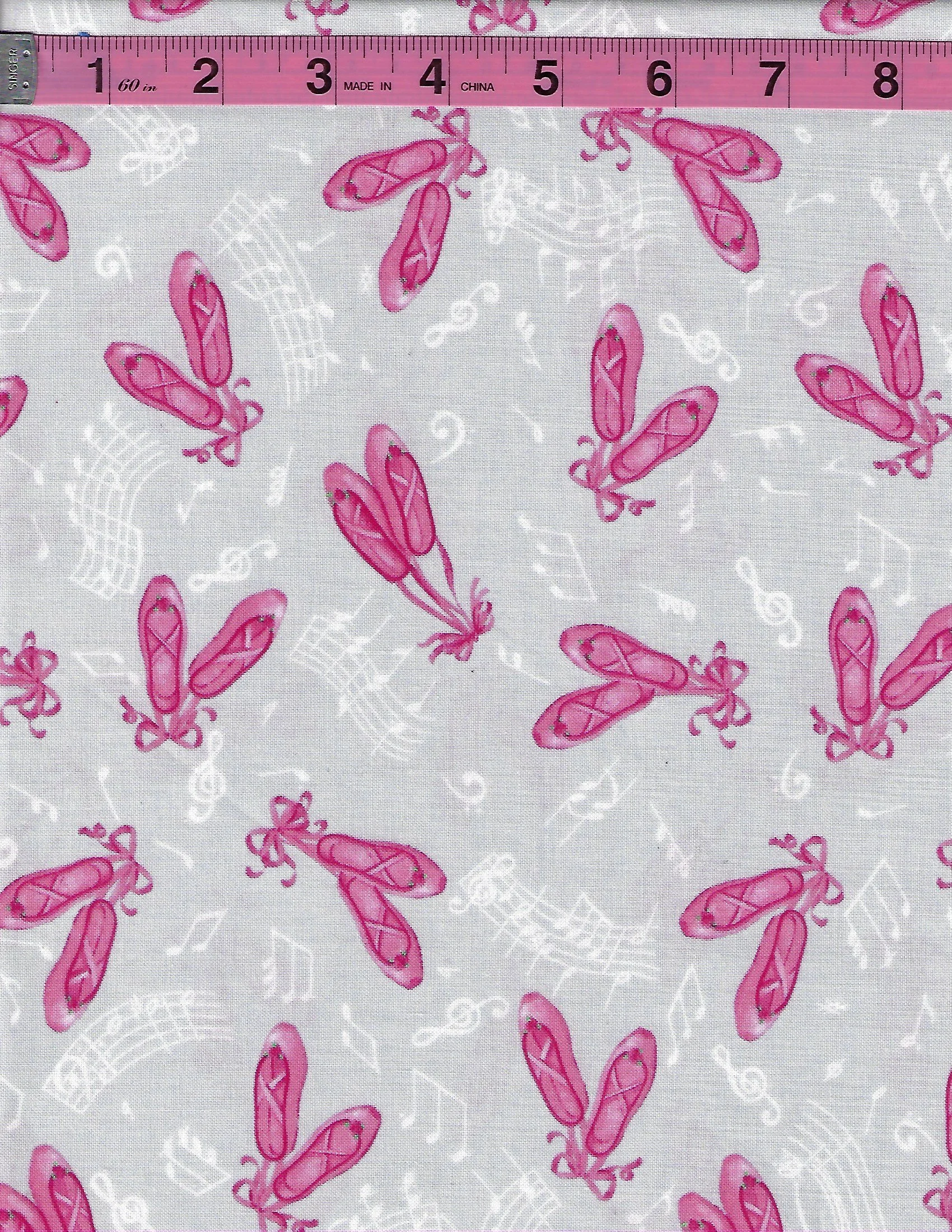 Pink ballet slippers and white music notes on a soft gray cotton fabric