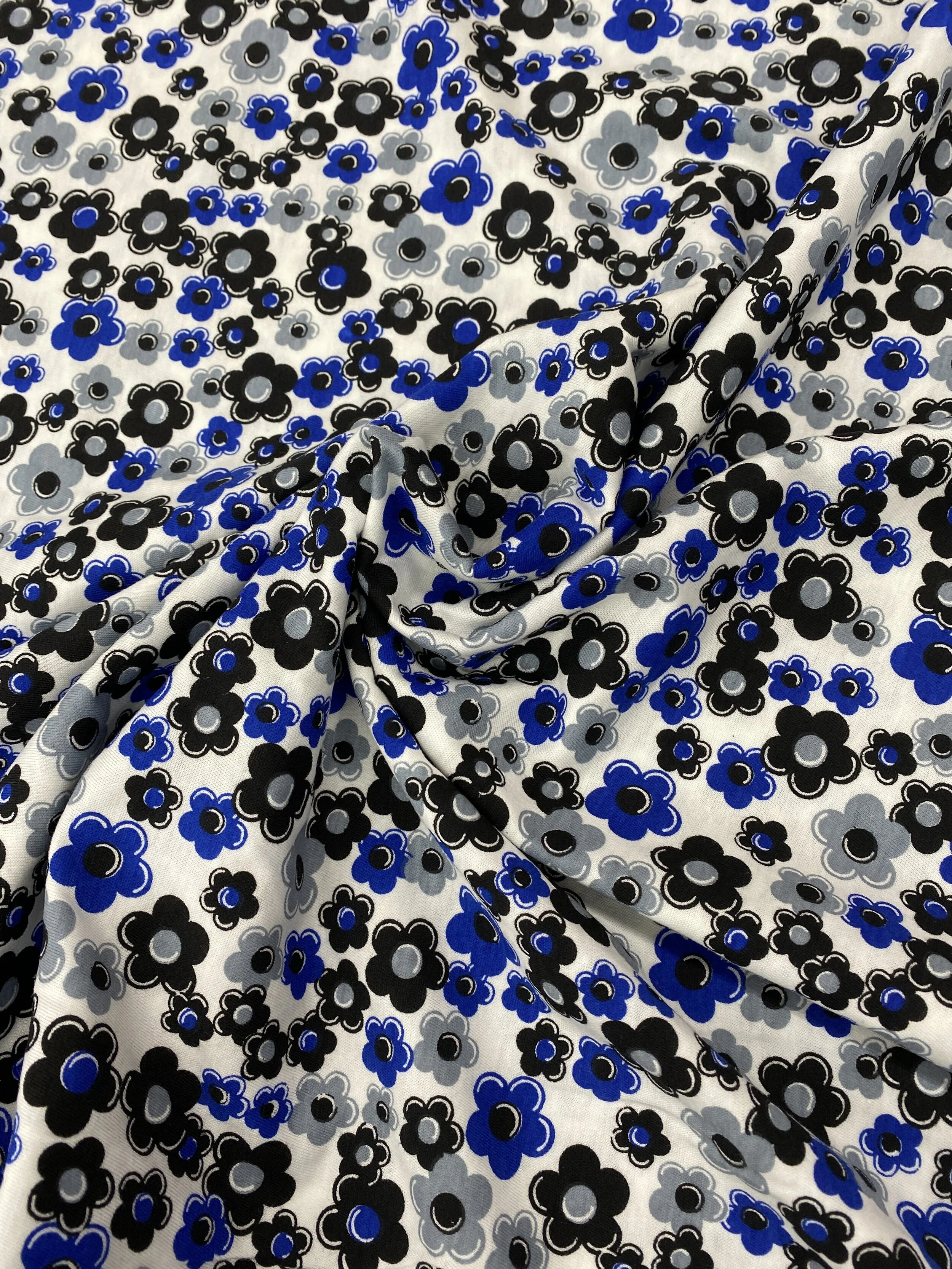 T Shirt Knit Fabric for apparel and garment sewing. Blue back and grey floral on white background.