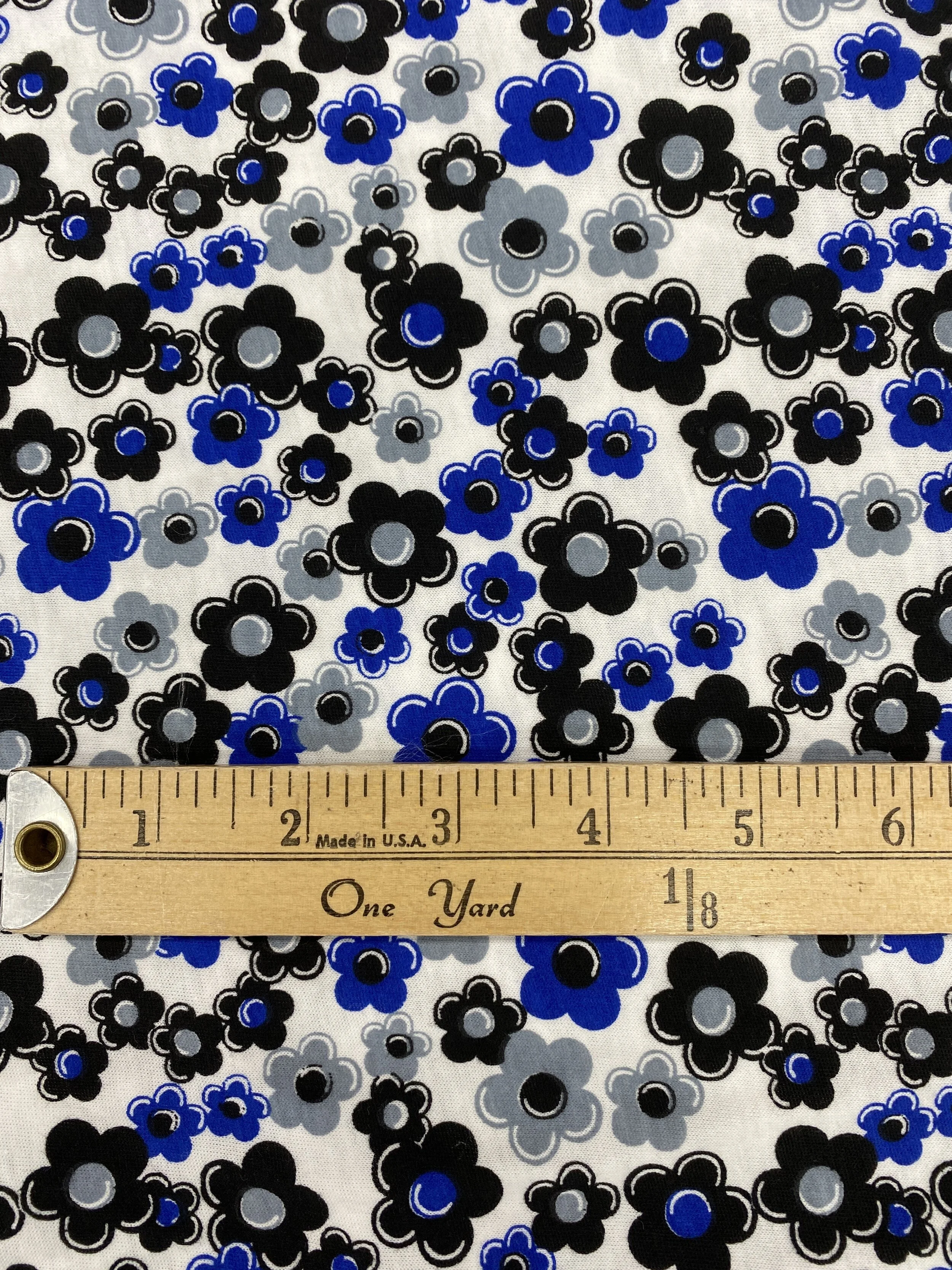 T Shirt Knit Fabric for apparel and garment sewing. Blue back and grey floral on white background.