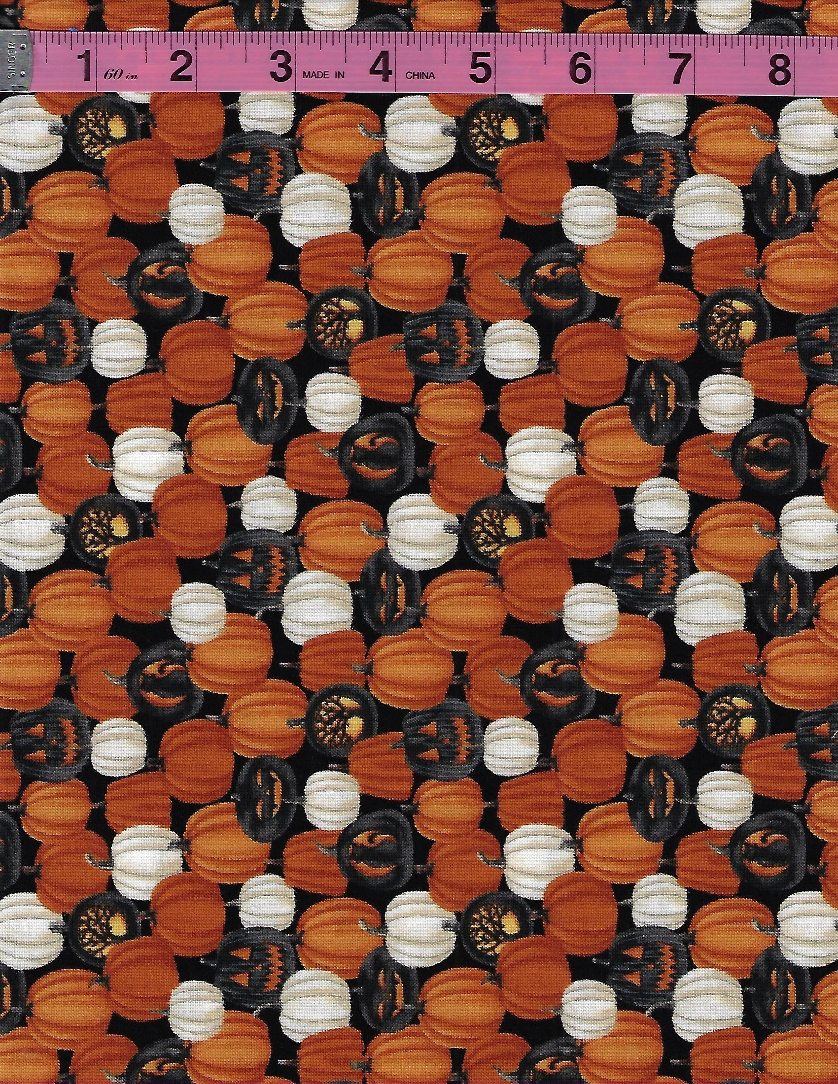 Studio E Harvest Moon 100% cotton fabric featuring orange, white and black pumpkins on a black background
