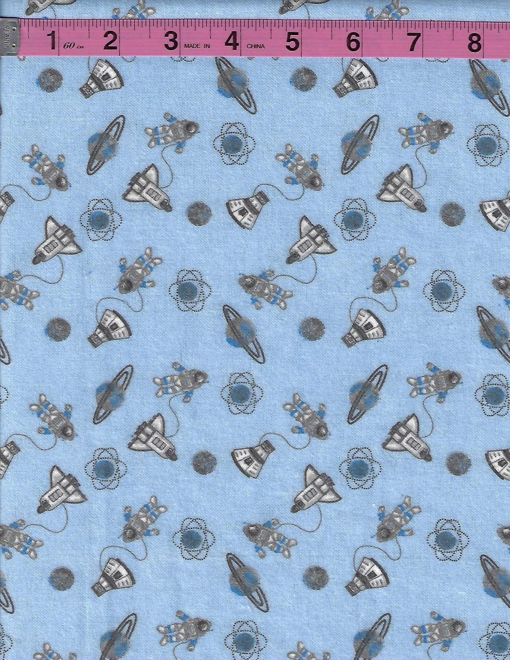 Light blue cotton flannel fabric with astronauts, rockets, planets, and space-themed motifs