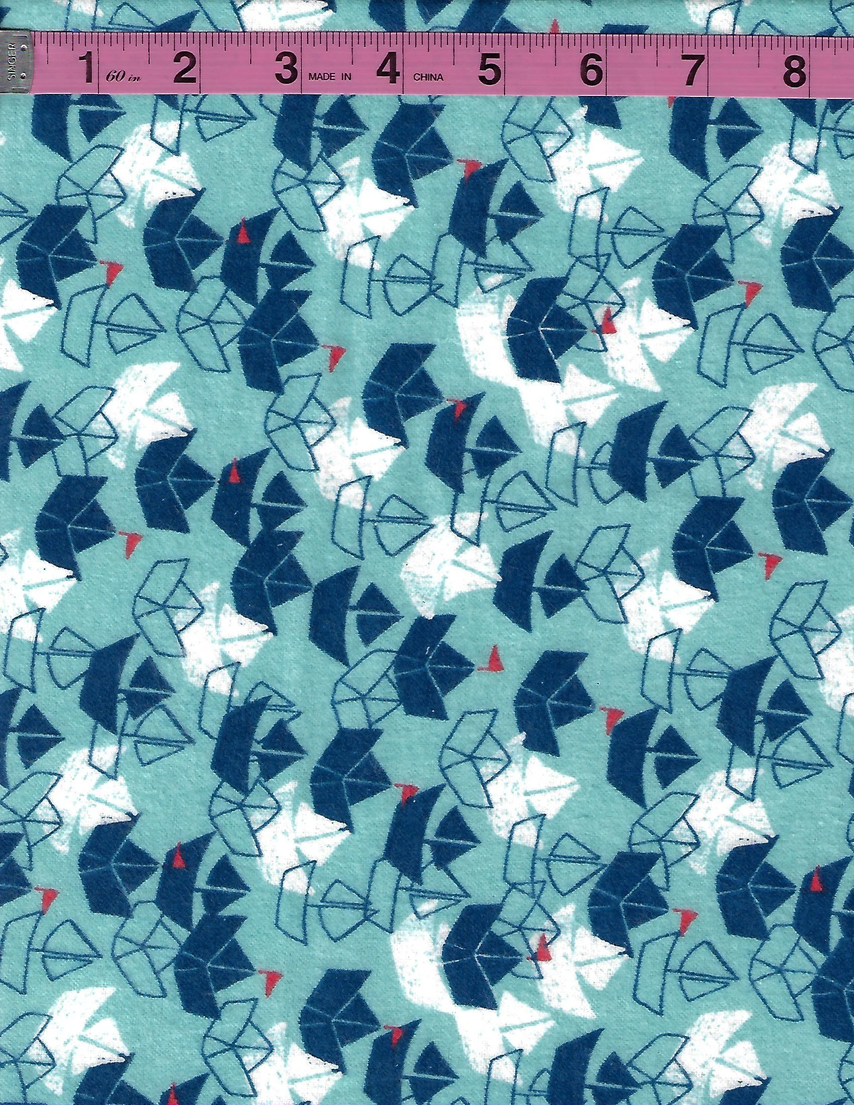 3 Wishes 100% cotton flannel fabric with playful navy, white, and red sailboats on an aqua blue background, shown with a measuring tape.