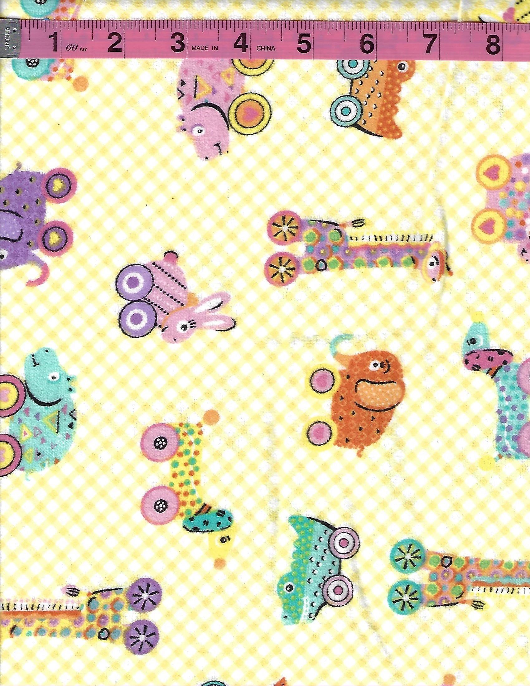 A.E. Nathan Comfy Prints 100% cotton flannel with colorful children's toy designs on a yellow and cream gingham background