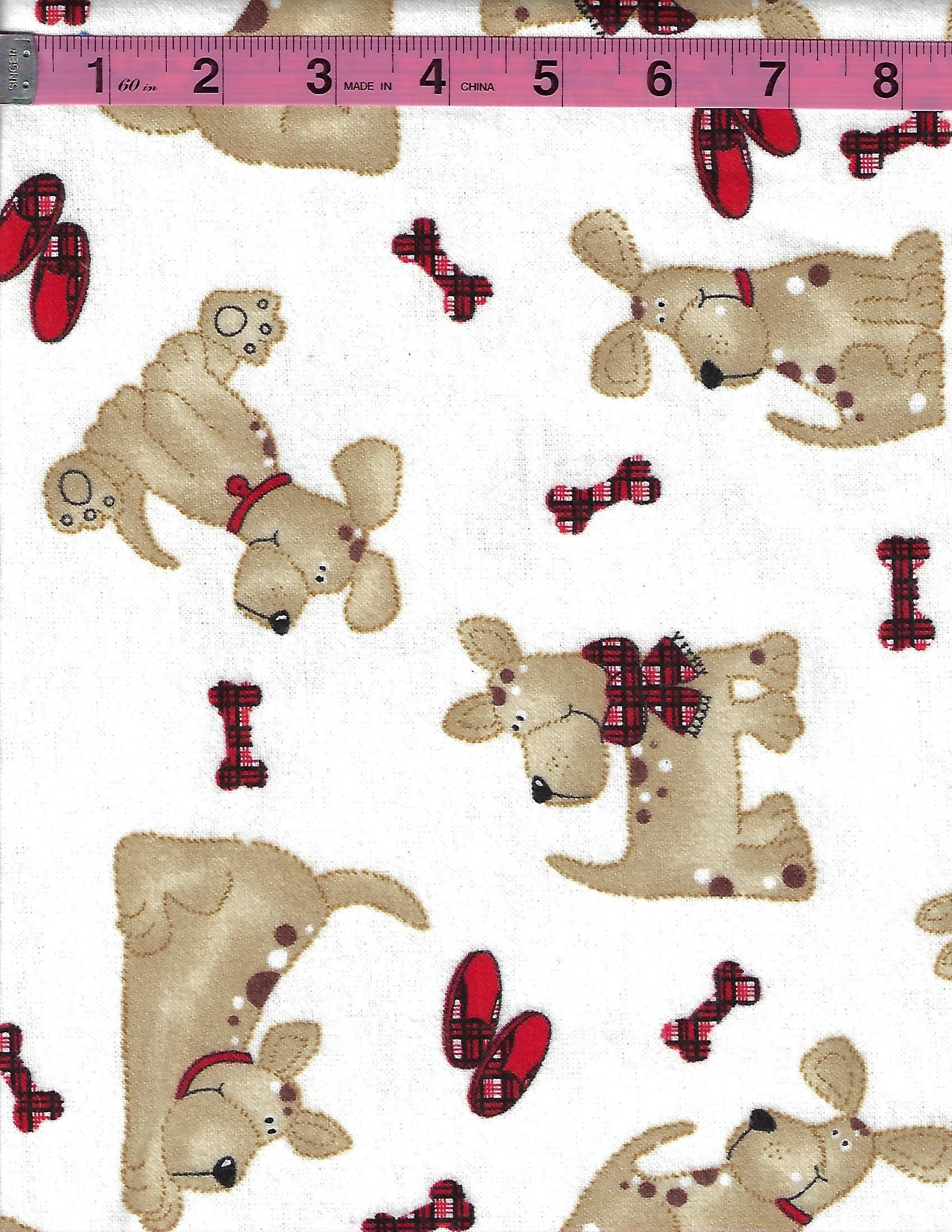 A.E. Nathan Comfy Prints 100% cotton flannel with cute tan puppies, red collars, plaid bows, dog bones, and red shoes on a cream background