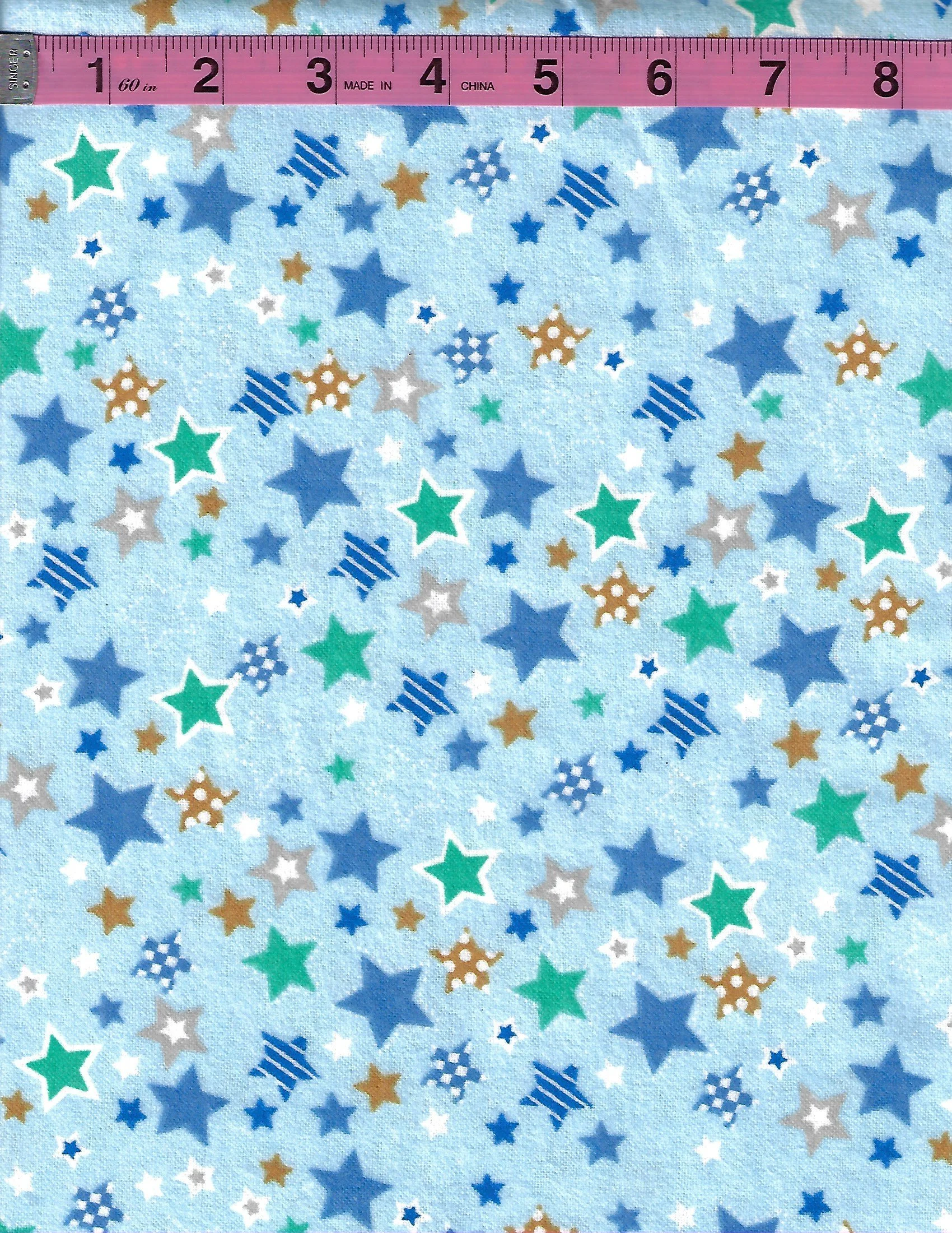 100% cotton fabric with colorful blue, green, gold, white and gray stars on a light blue background