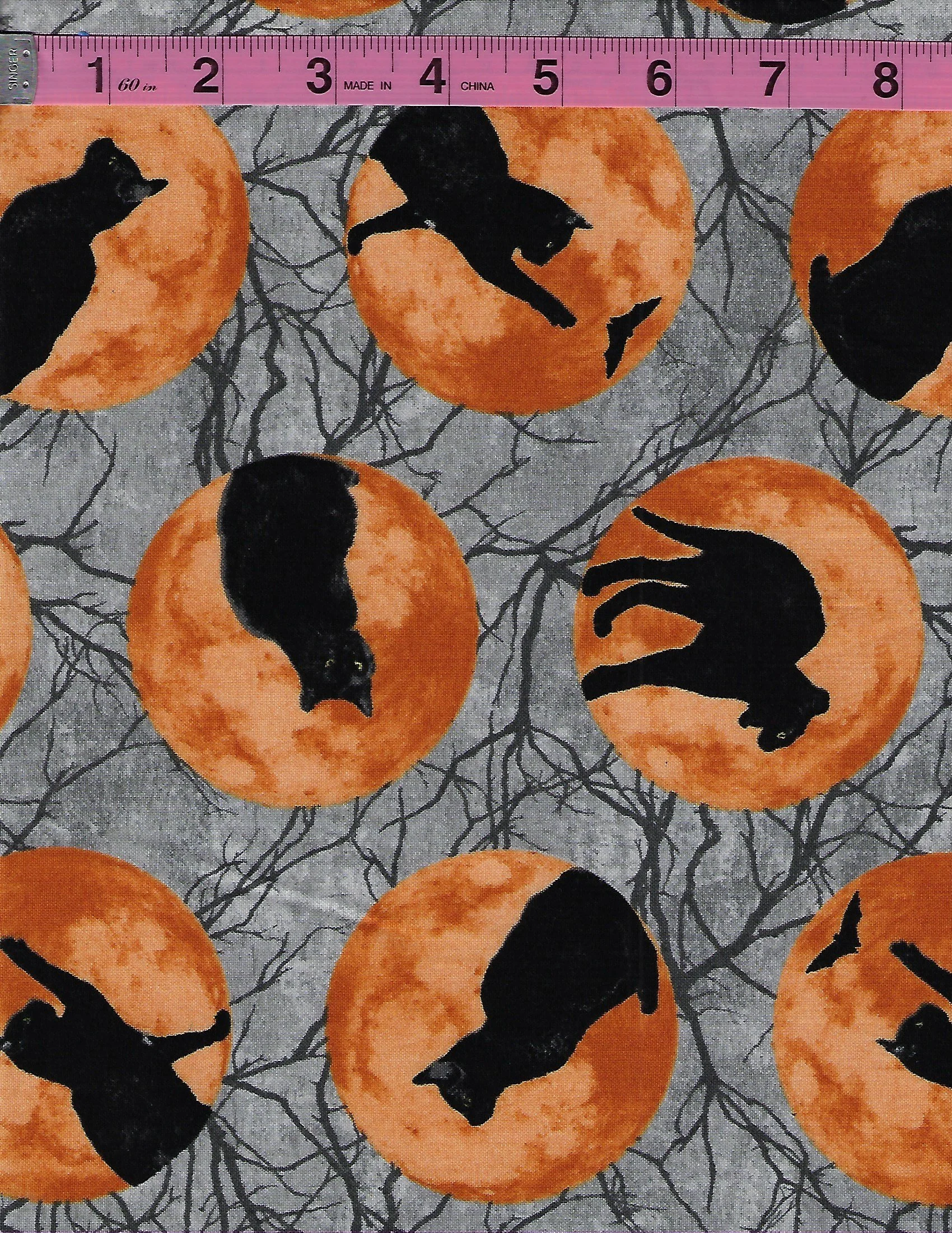 Halloween cotton fabrics featuring black cats on orange full moons and black cats with glowing yellow eyes