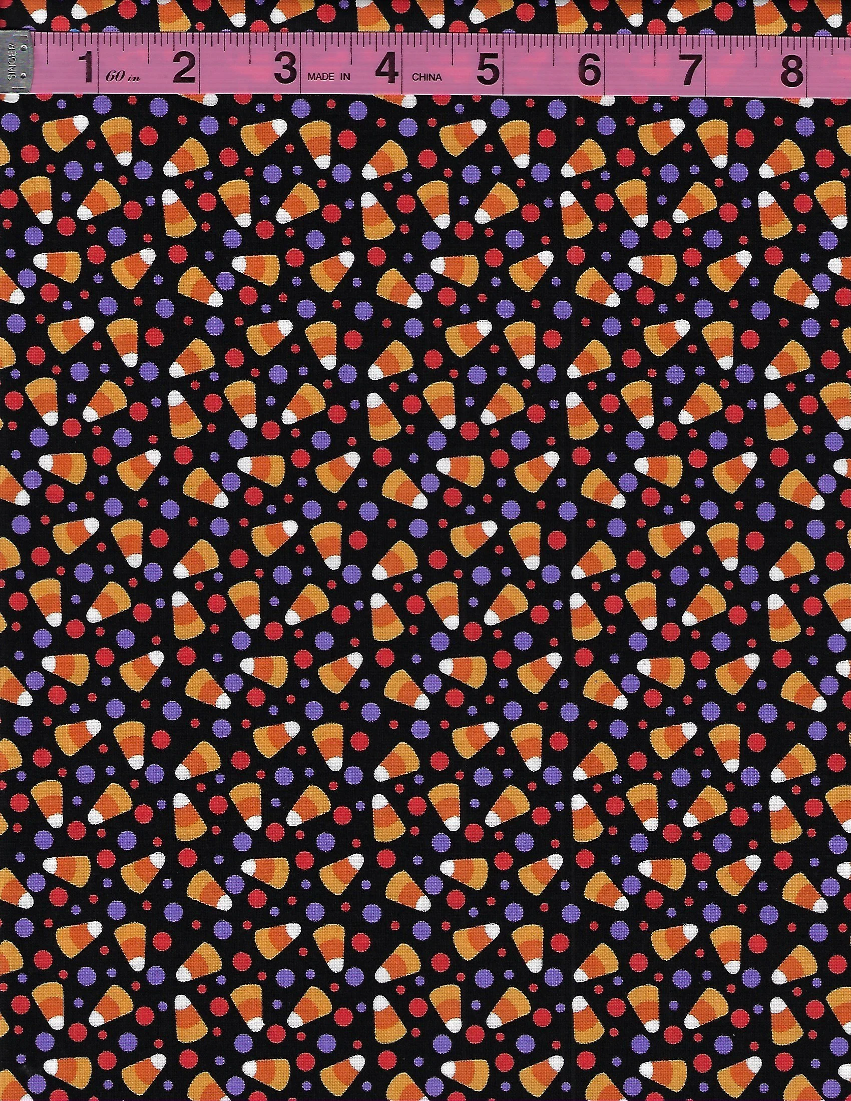 Blank Quilting Witchful Thinking Halloween fabric featuring colorful candy corn and red and purple dots on a black background.