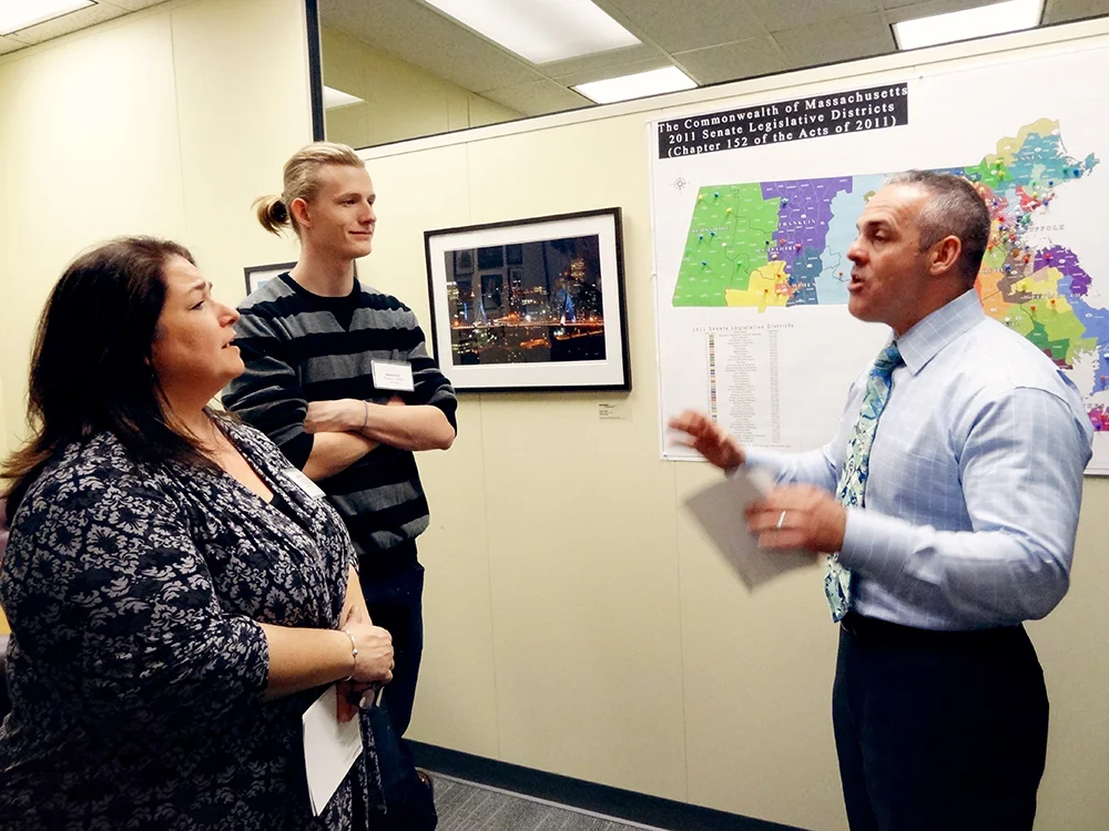 Some very intense conversation is happening as Matt Malone speaks to Shawn Kelley and Elizabeth DiCicco at the Executive Office of Education Art Exhibition, 2013.