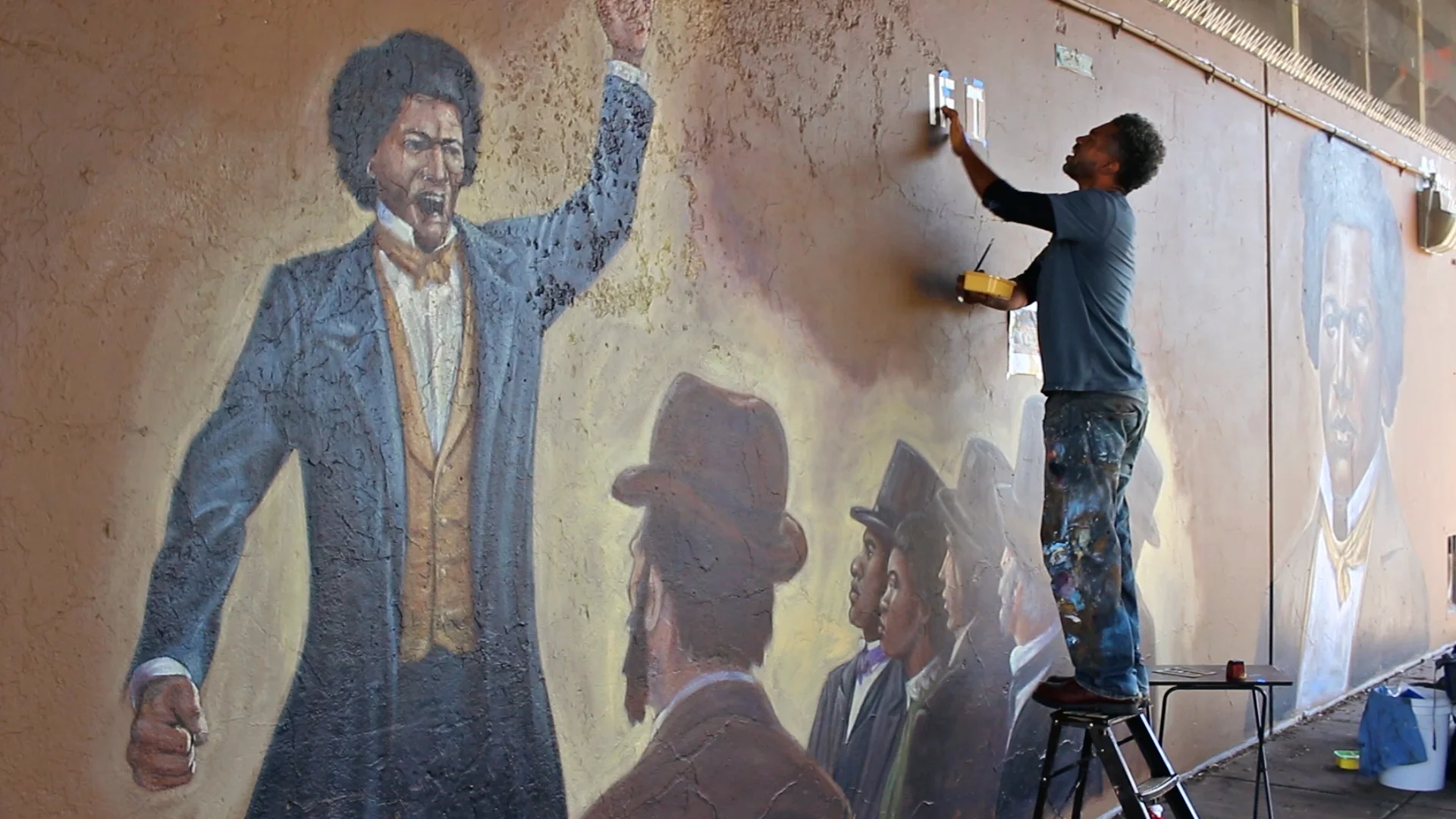 Children's book illustrator London Ladd paints murals of Frederick Douglass and Martin Luther King Jr. in Syracuse, NY, 2018.